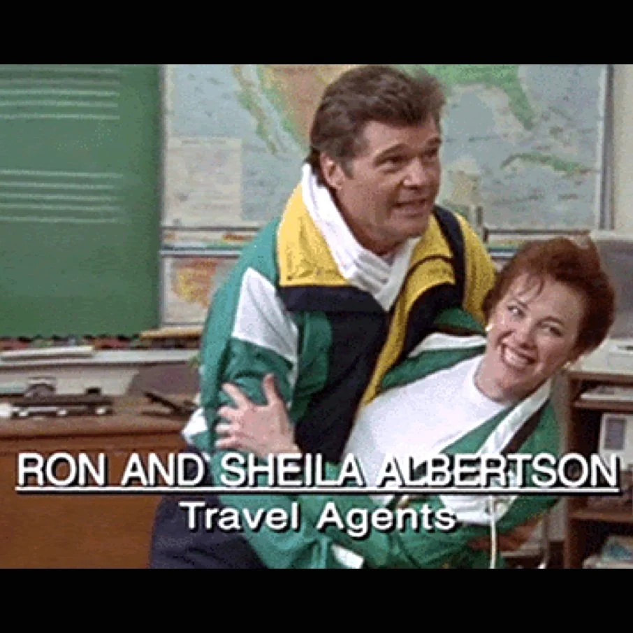 Still image from "Waiting For Guffman" showing Catherine O'Hara and Fred Willard as "Ron and Sheila Albertson: Travel Agents". They are performing, she is in his arms as he dips her. Wearing matching track suits, green yellow and blue