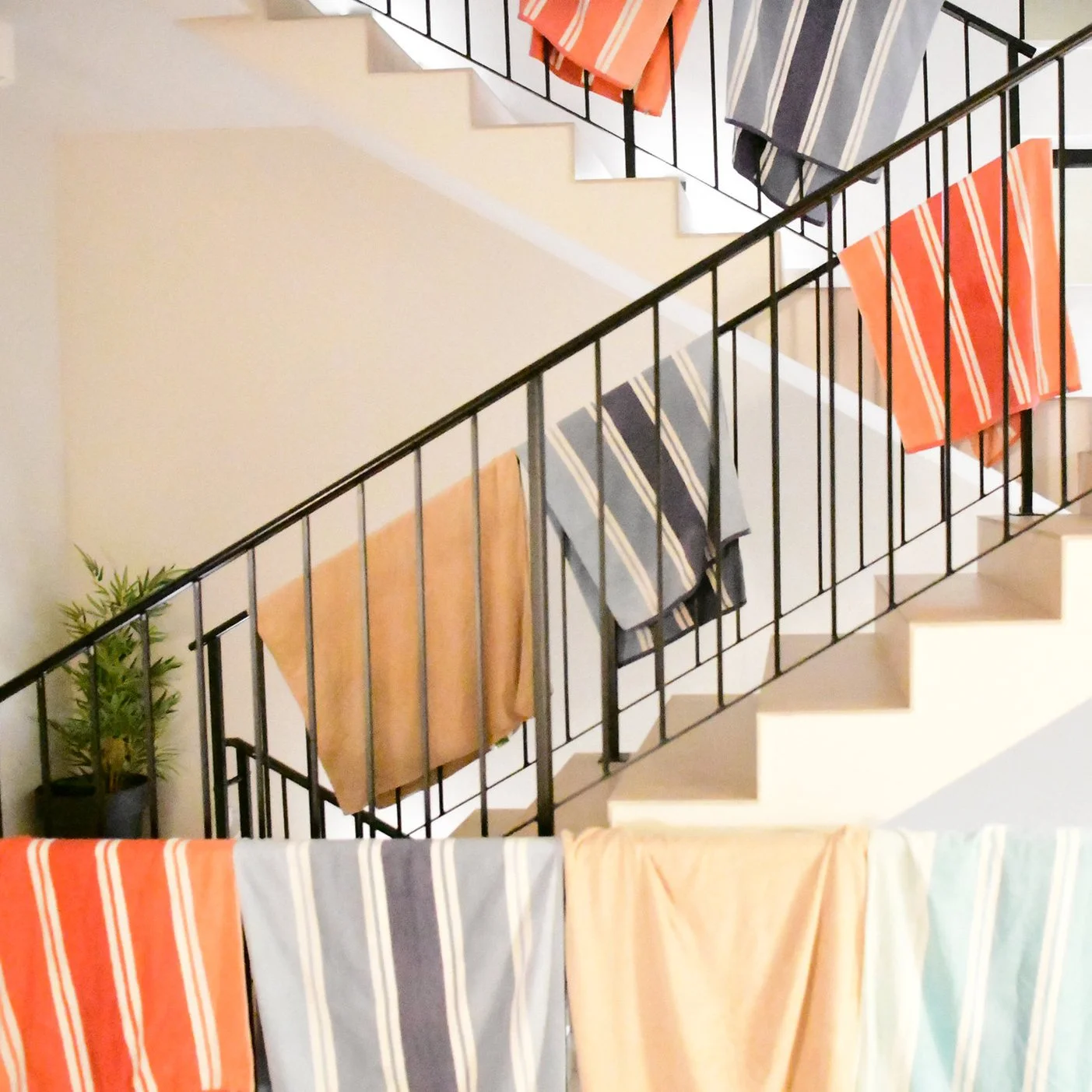 Photo of many towels hanging on the handrail of a staircasse