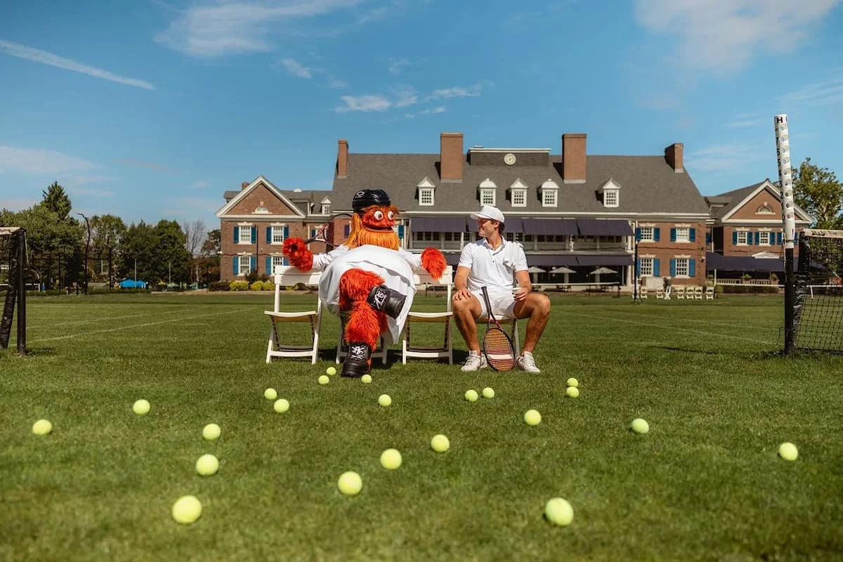 Philadelphia Flyer's mascot sitting next to a tennis player at a university in Philadelphia, PA