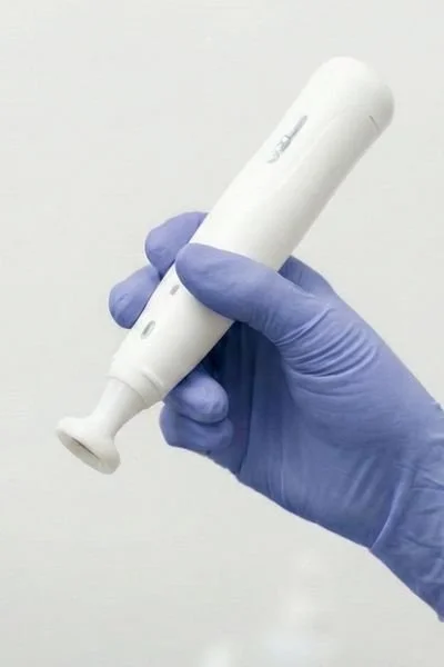 Blue gloved hand holds a Jet Plasma device