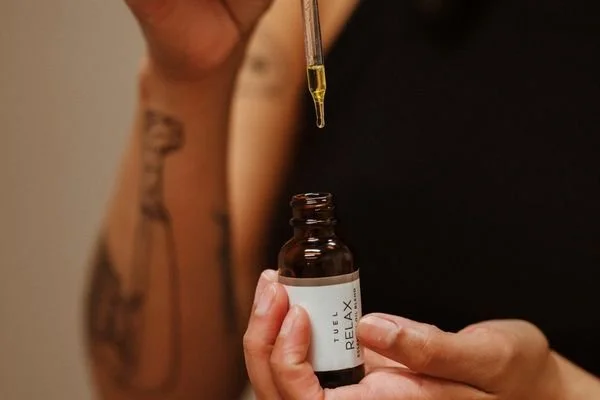 Anna Elizabeth Esthetics team member holds a bottle of Tuel Relax before a facial in Buffalo