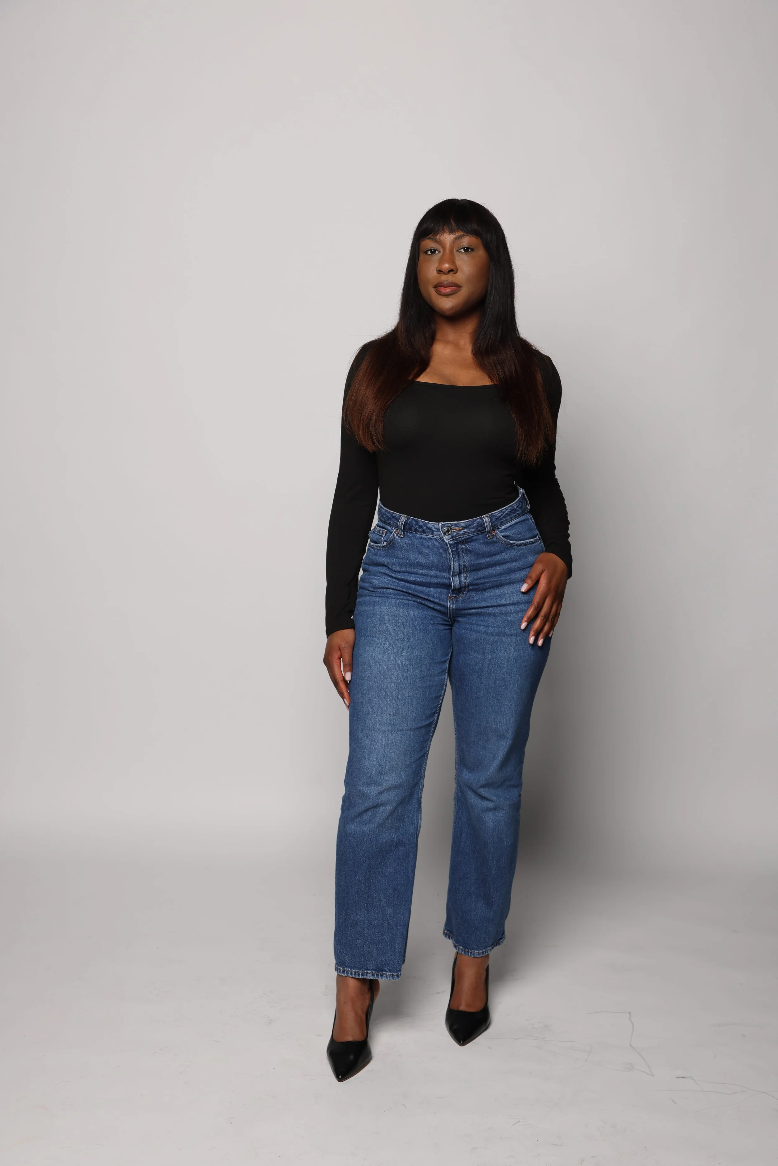 black hair woman black tshirt blue jean smiling2.jpg