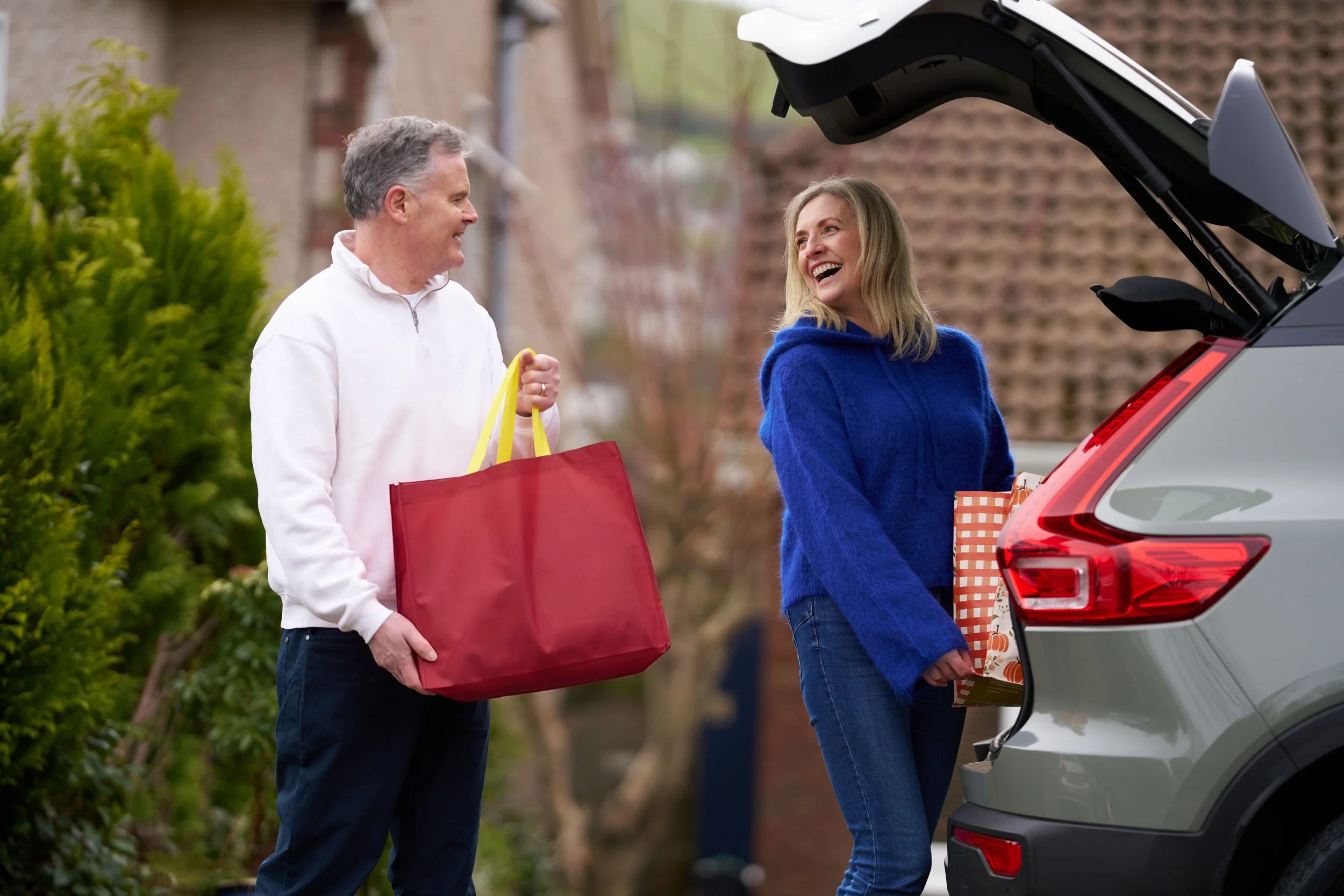 Aviva Insurance man and women placing groceries into back of car