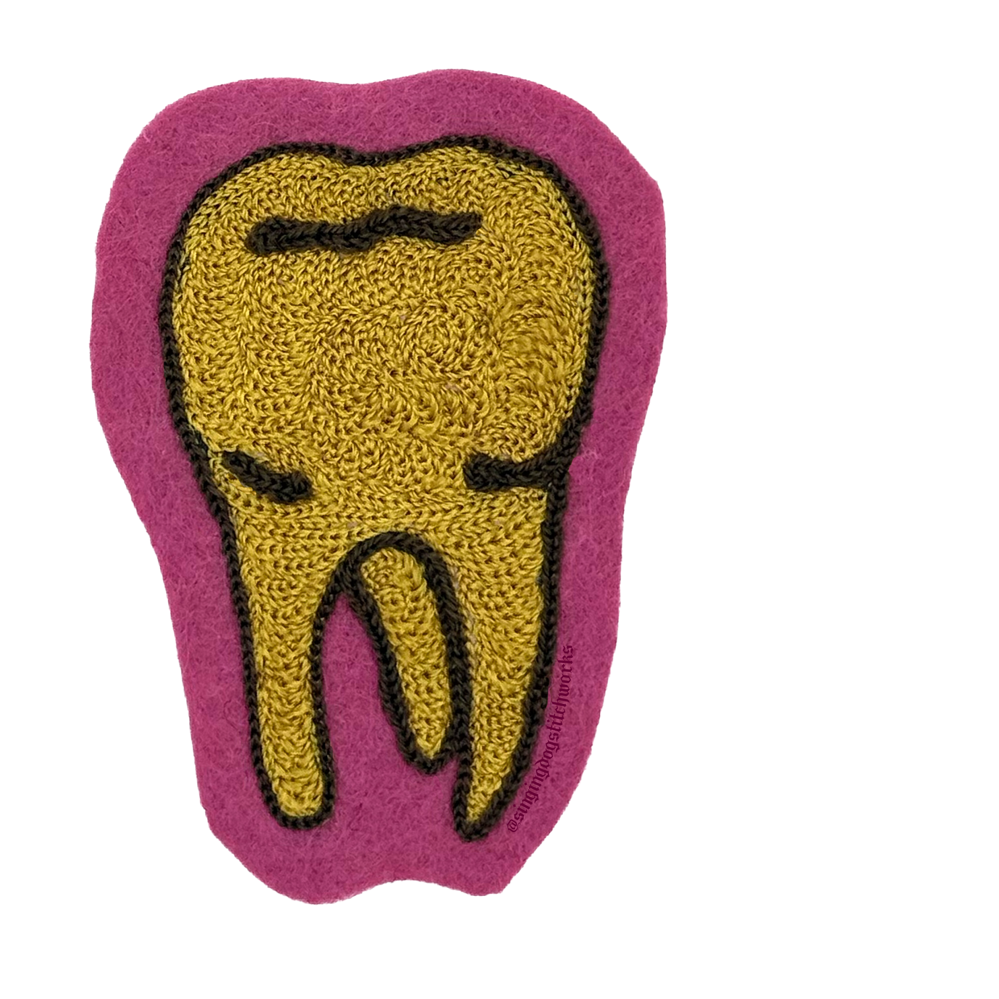Close-up of a pink embroidered patch with a yellow and black smiling scarecrow face stitched onto fabric.