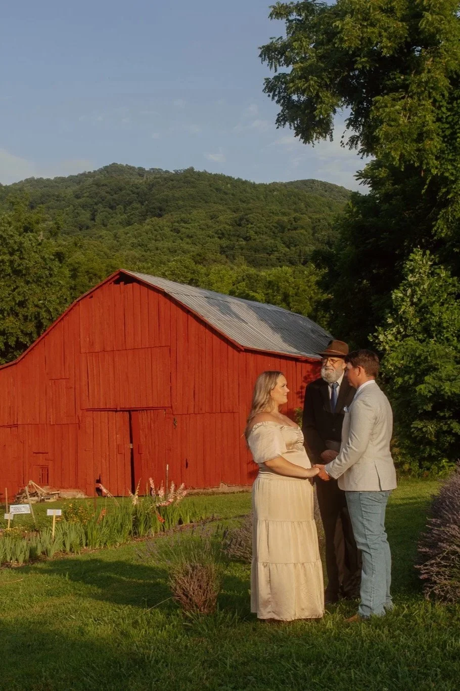 a couple gets married with an antique red barn and views of Buffalo Mountain in the background