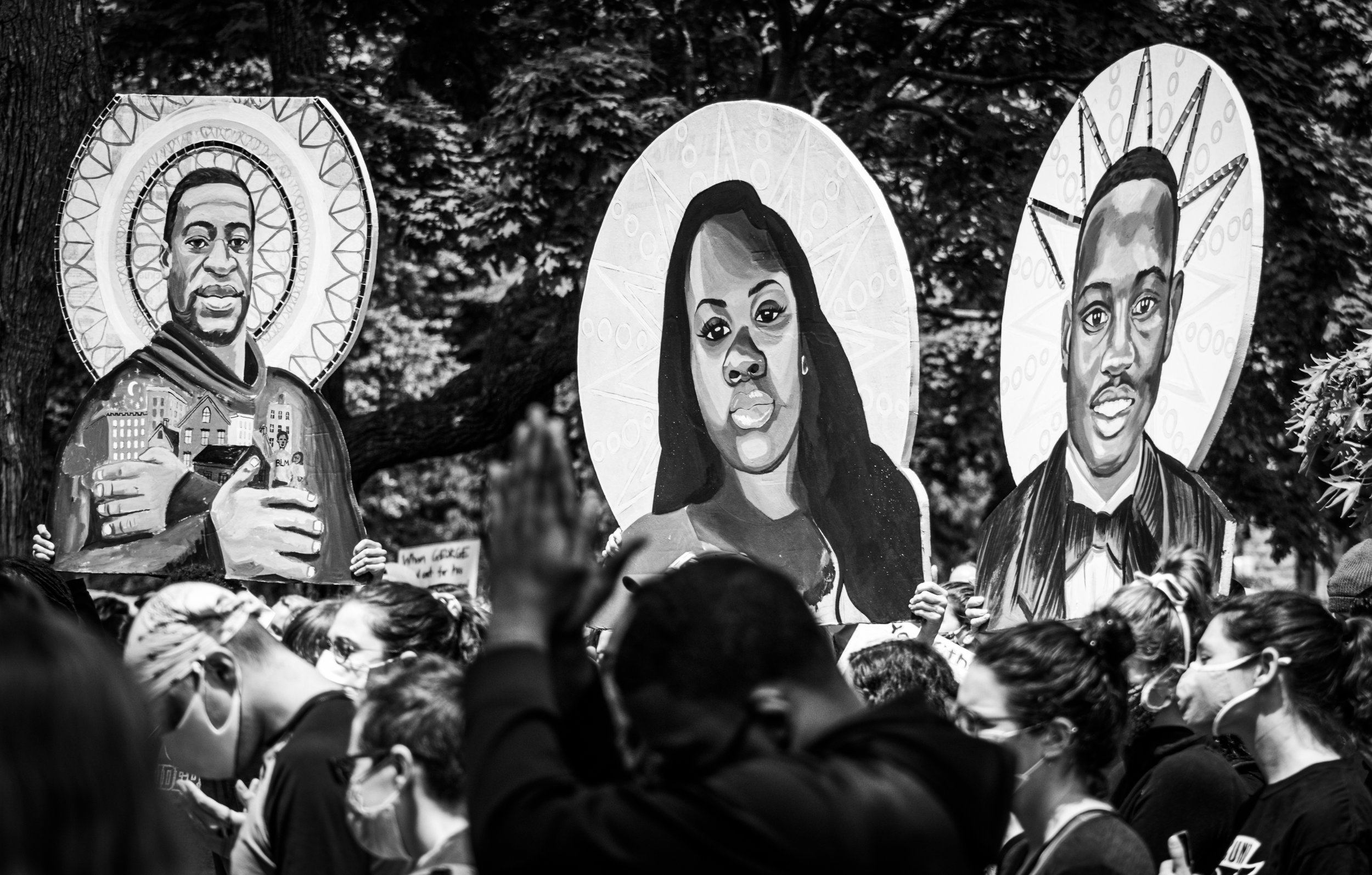 Signs of George Floyd, Breonna Taylor and Ahmaud Arbery are held above the crowd at a Black Lives Matter protest in Cambridge, Mass. on June 6, 2020.