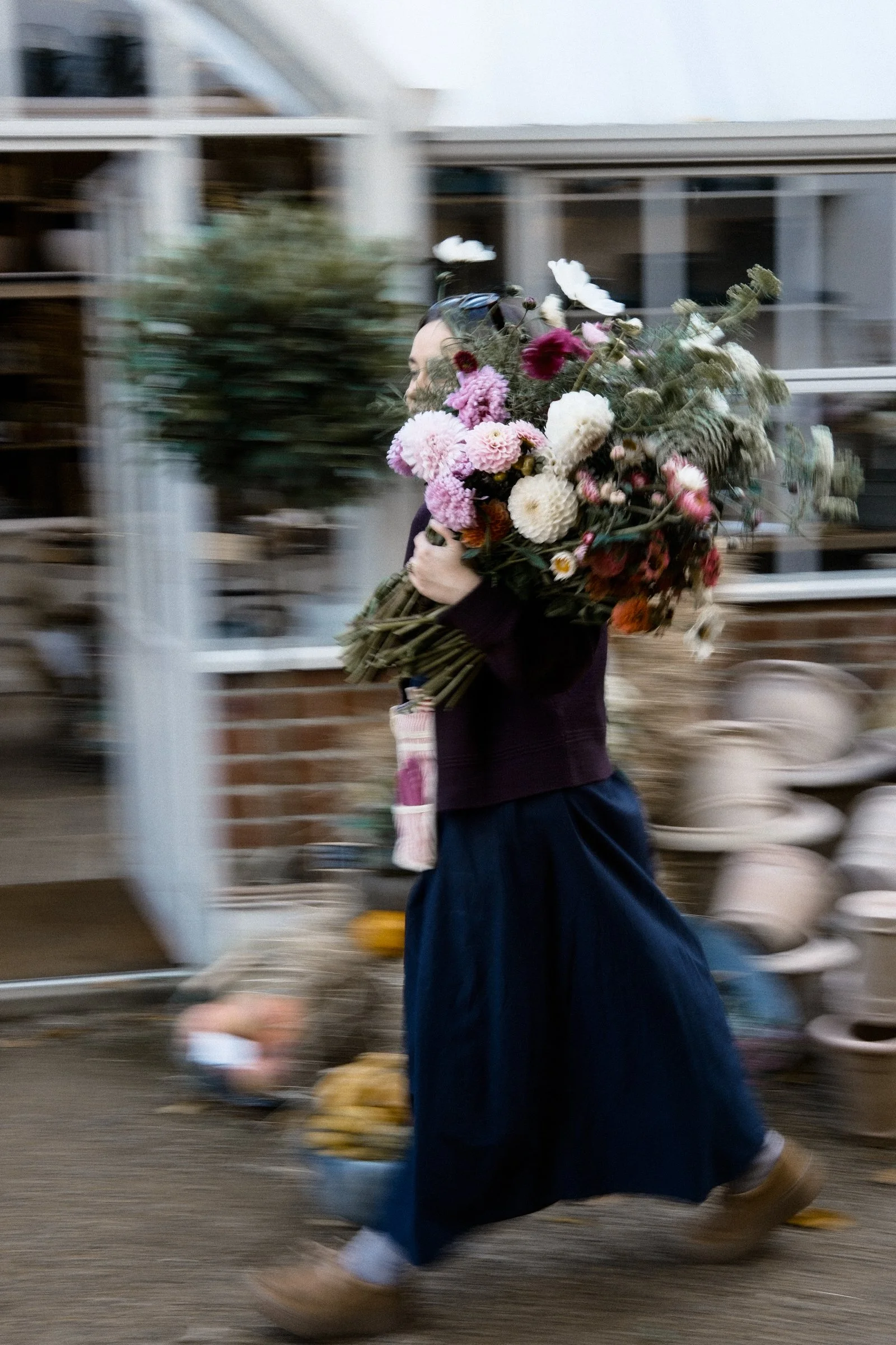 Florist carrying a large bouquet photographed during a HYGGE Floral Design Content Day.