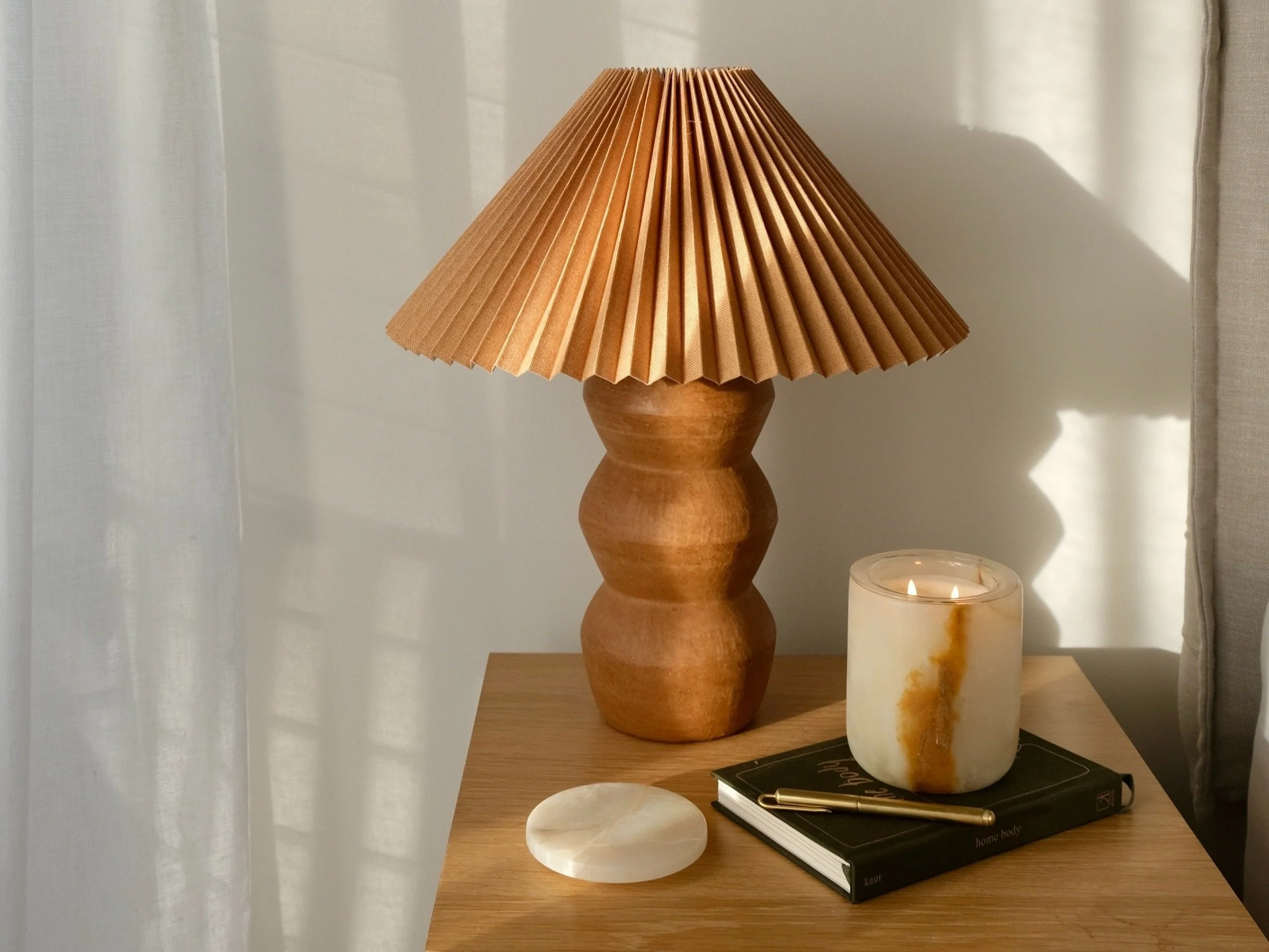 side table with lamp, candle and diary