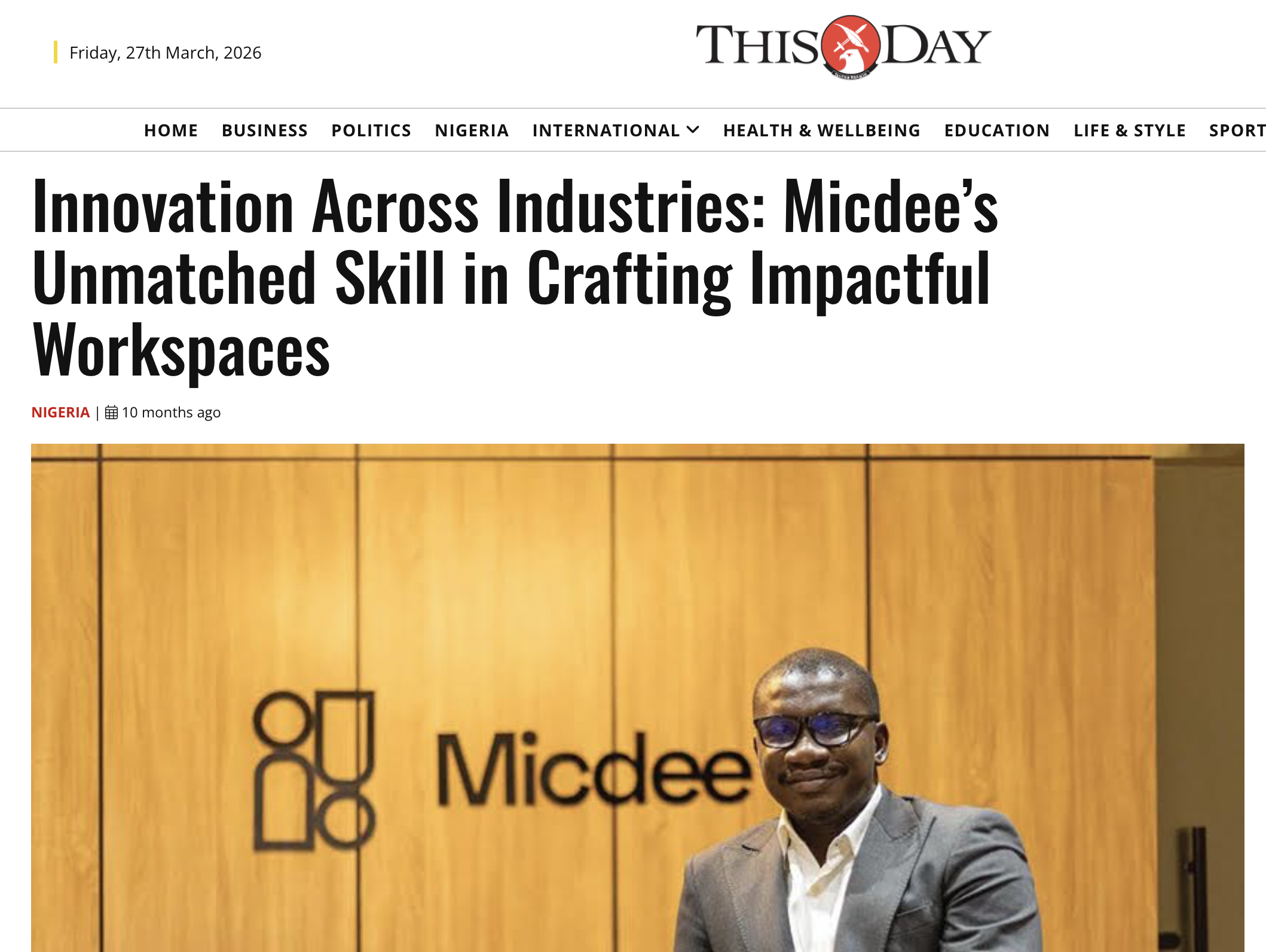 Michael Awonowo standing in front of a wooden wall with 'Micdee' logo and icon.