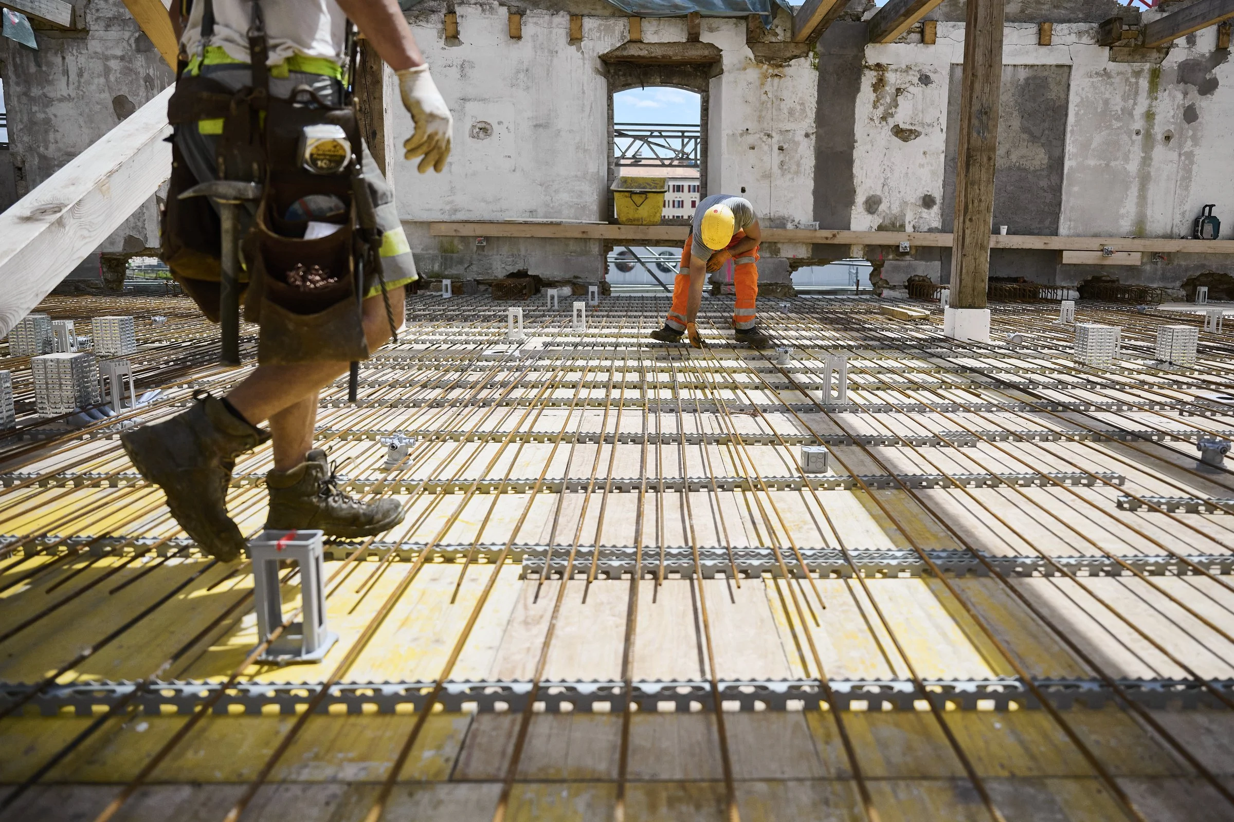 Ouvriers posant le ferraillage d'une dalle, reportage de chantier de construction à Neuchâtel