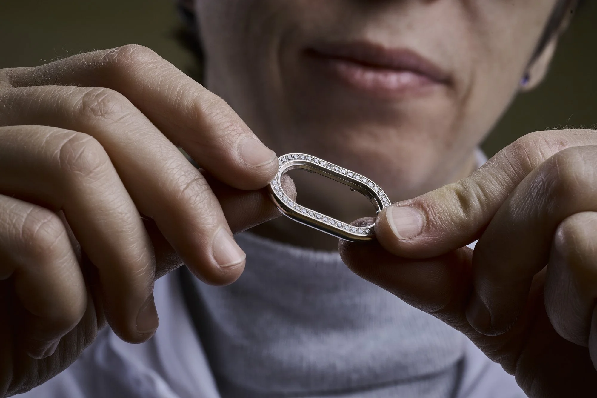 Sertisseuse contrôlant un composant serti de diamants, métier d'art horloger, watch photography Suisse