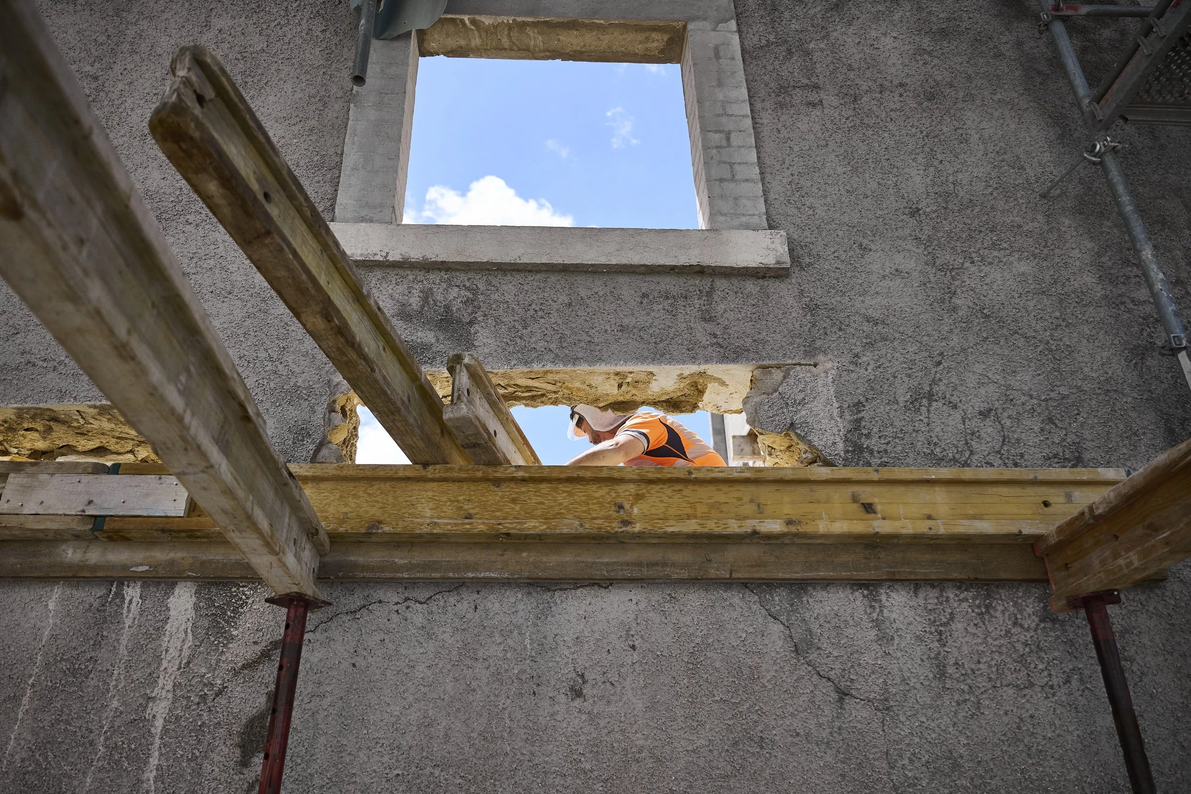 Ouvrier travaillant sur un chantier vue à travers une fenêtre, reportage de chantier à Neuchâtel