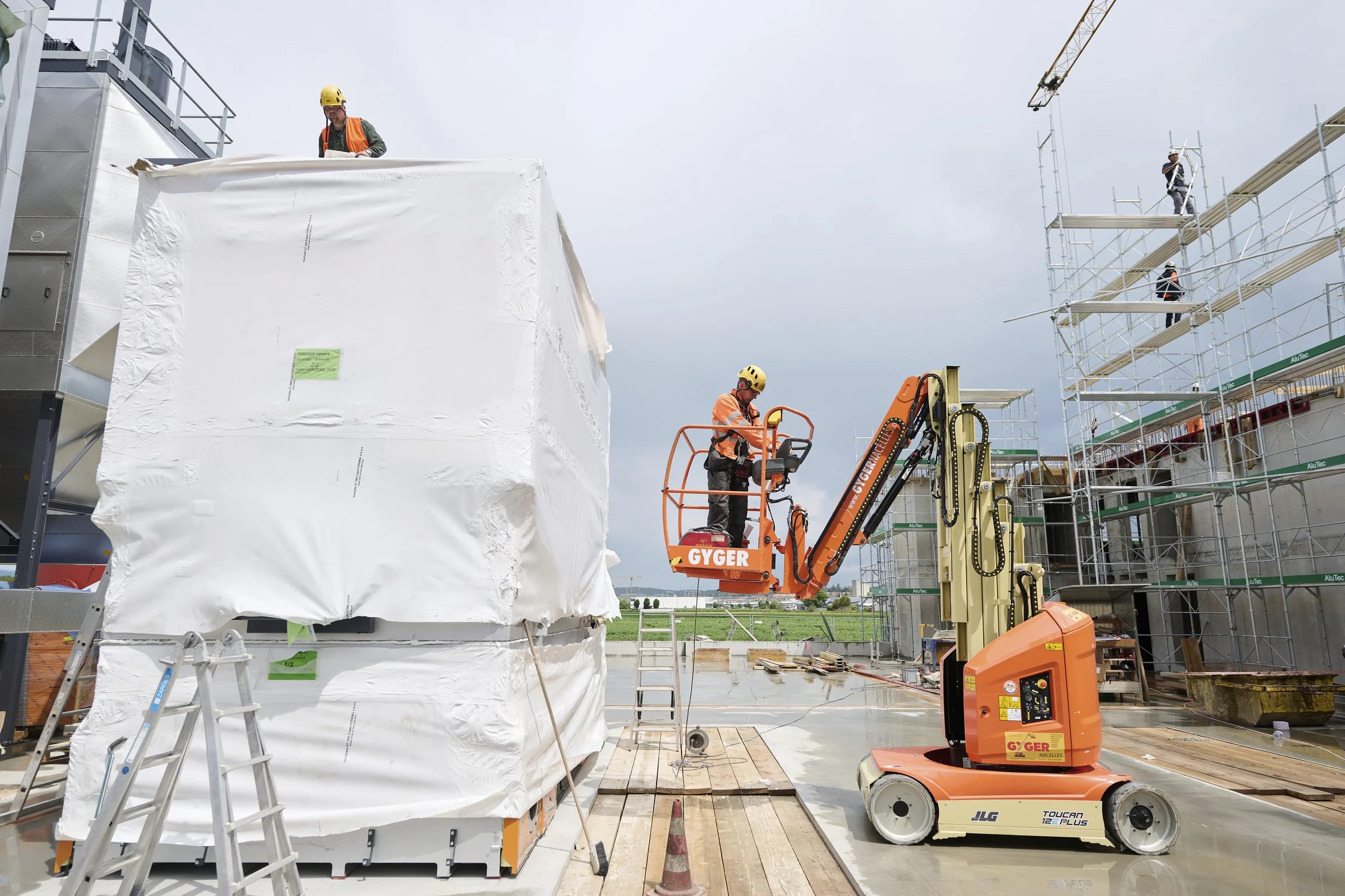 Chantier de construction avec nacelle élévatrice et matériel protégé, photographie de chantier à Neuchâtel