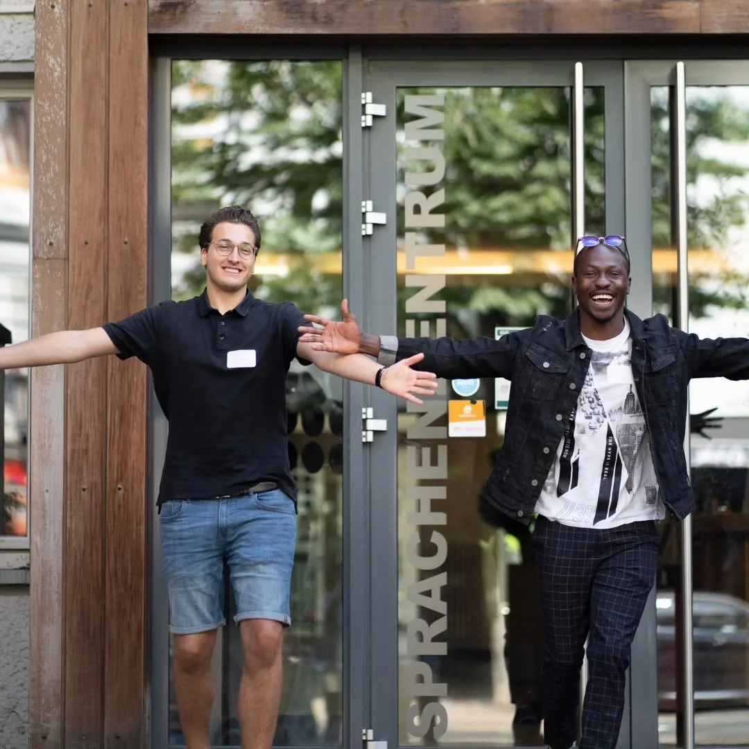 Friendly welcome team greeting visitors at the entrance of our international church Berlin before the Sunday service.