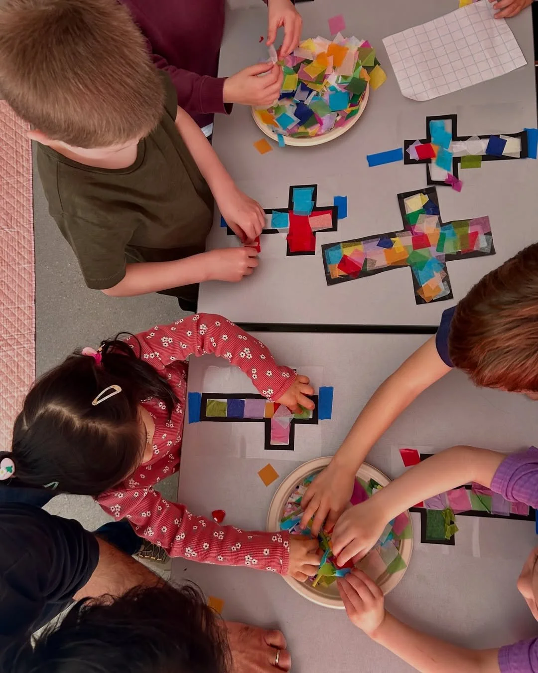 Kita-age children working together on paper cross crafts during KiGo activities at our English-speaking church Berlin, where we offer bilingual programs in English and German.