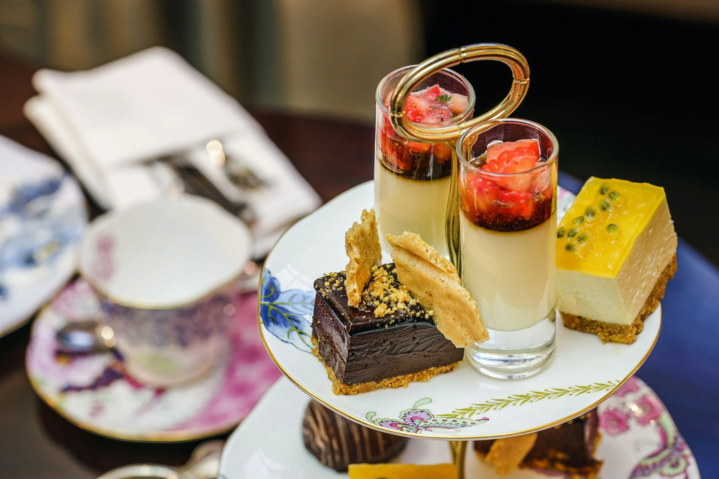 Afternoon tea is served with a selection of small cakes on a two-tier cake stand.