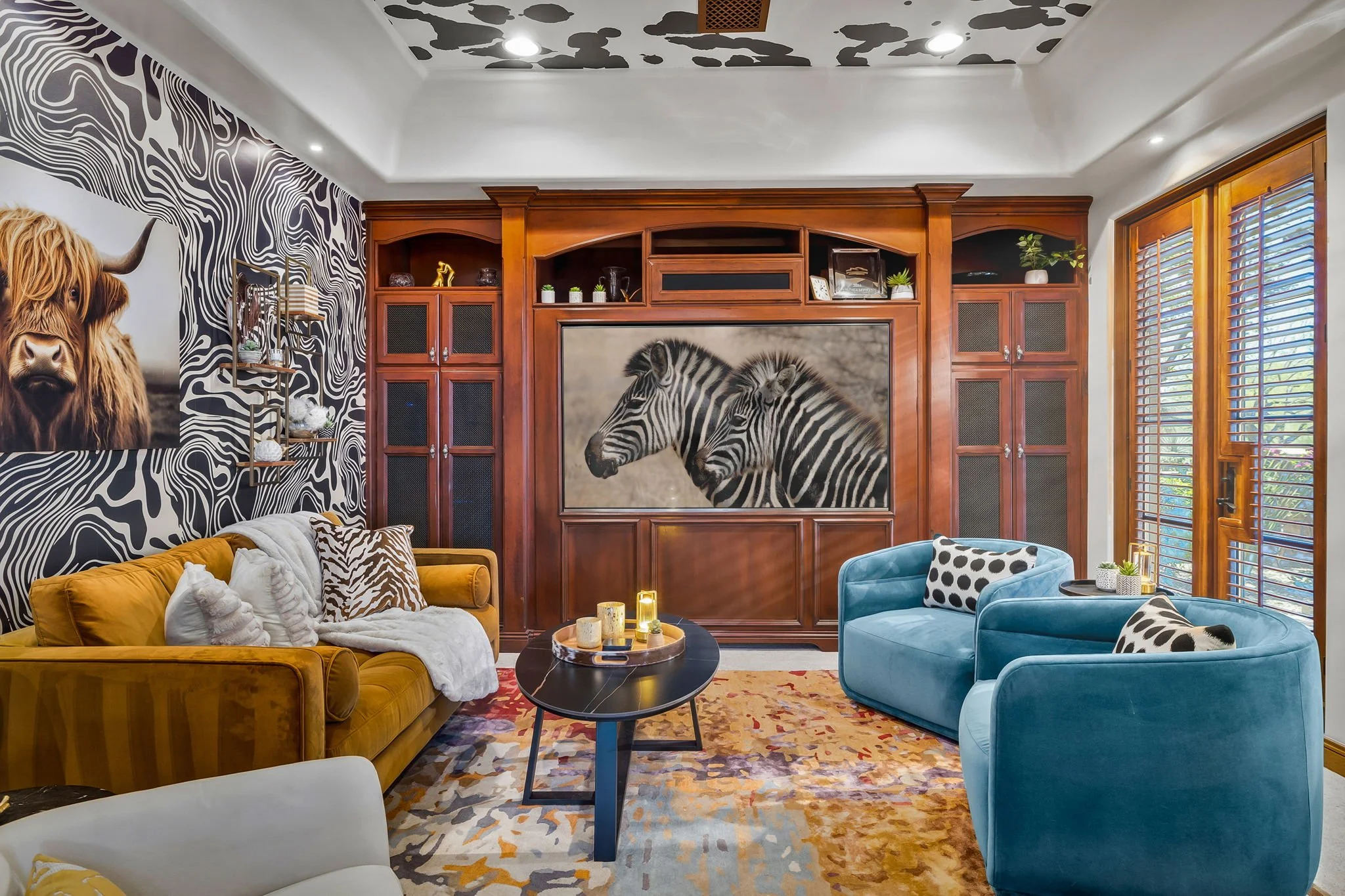 Bold lounge redesign featuring zebra wallpaper, cowhide ceiling details, and rich wood built-ins by Red Carrot Design in Gold Canyon, AZ.