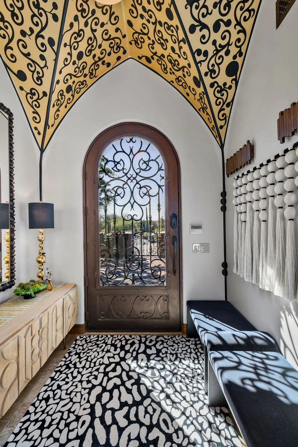 Luxury entryway with a stenciled vaulted ceiling, animal print rug, and custom built-in bench by Red Carrot Design in Gold Canyon, AZ.