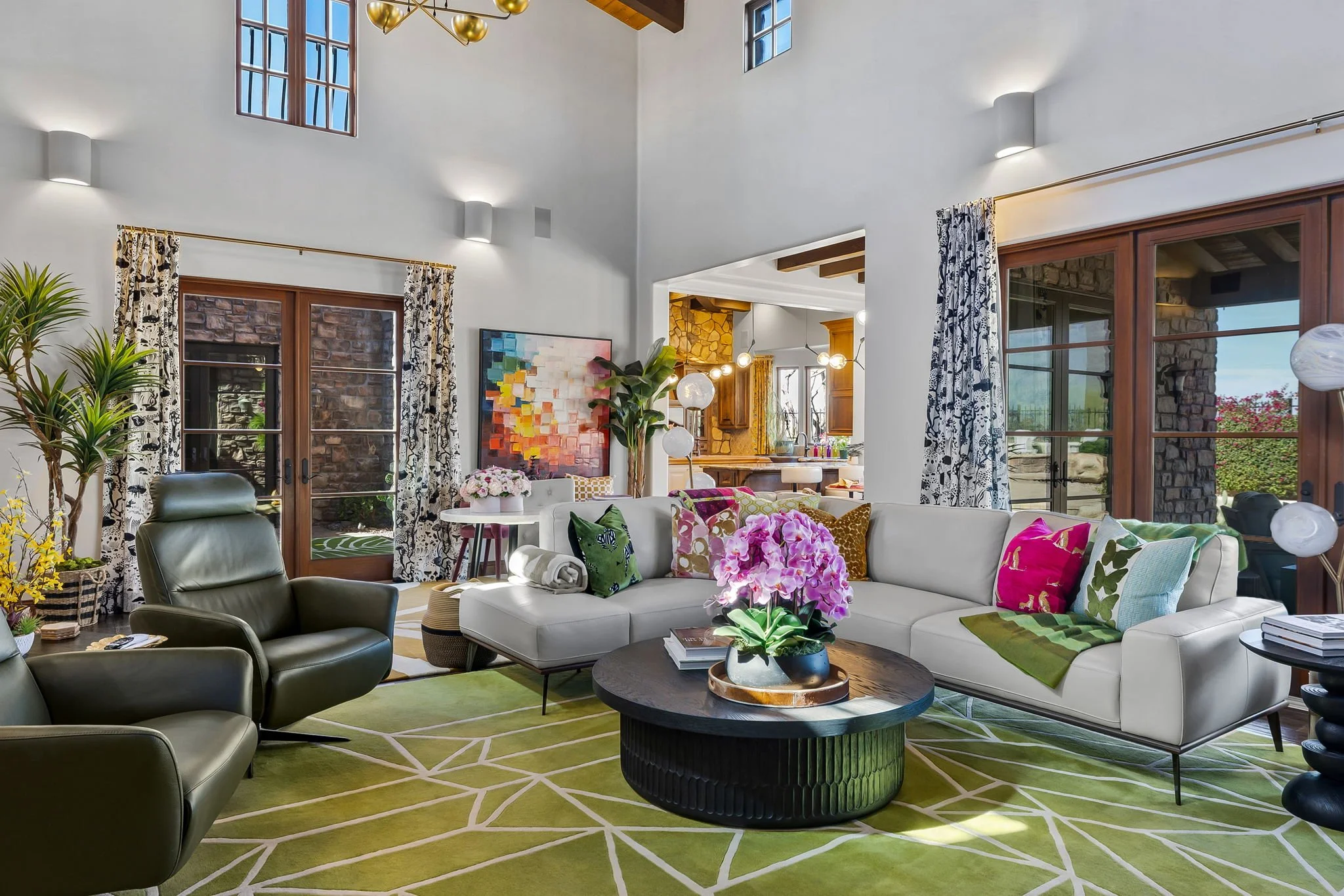 Open concept living room with a lime green geometric rug and colorful accents in Superstition Mountain, Gold Canyon, AZ, by Red Carrot Design.