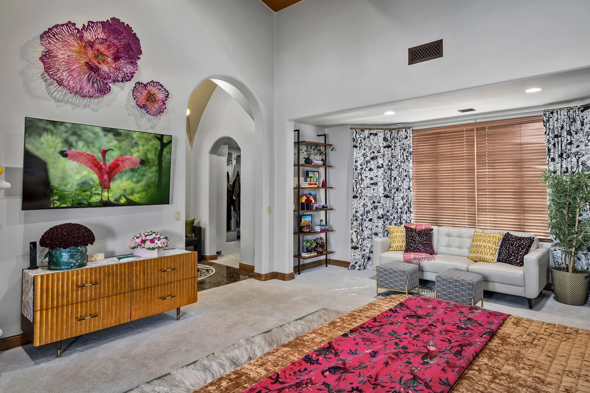 Primary bedroom suite featuring a white leather sofa, patterned ottomans, and black-and-white toile drapery in Gold Canyon, AZ, by Red Carrot Design.
