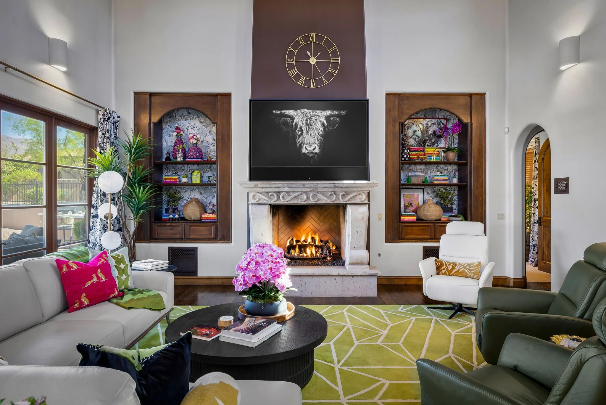 Grand stone fireplace with built-in arched shelving and highland cow art in a Red Carrot Design project, Gold Canyon, AZ.