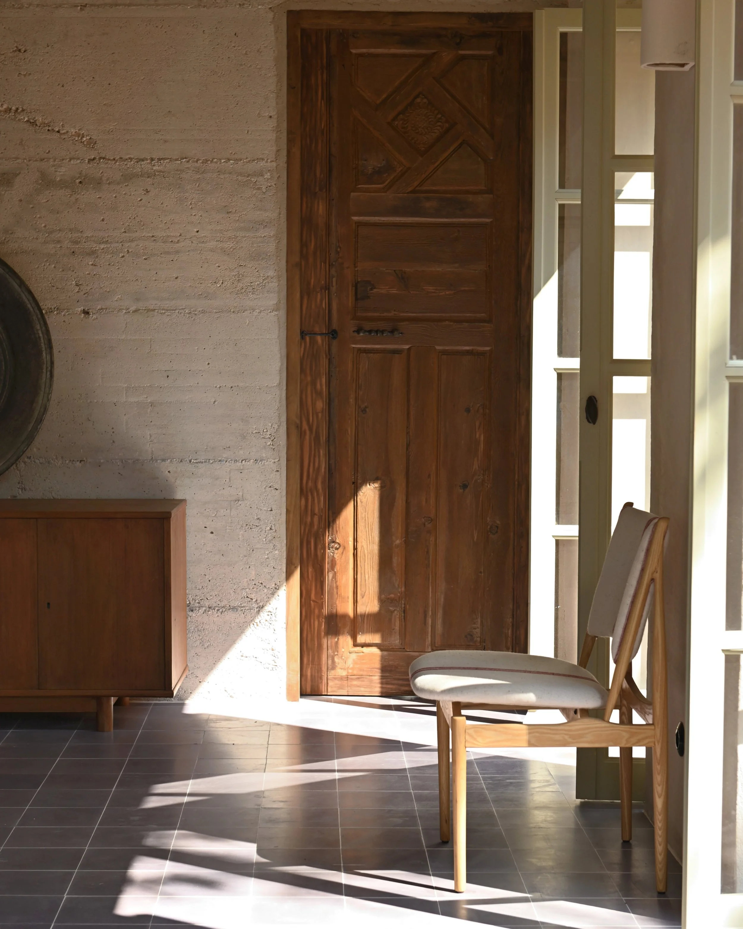 Step into the welcoming ambiance of Casa Mediterraneo Hotel in Kastellorizo, Megisti, as you enter our reception area. Sunlight bathes the space, highlighting the unique combination of concrete walls and vintage wooden doors sourced from Turkey, crea