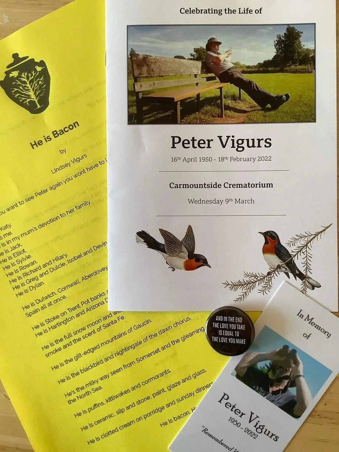 Funeral pamphlets and card for Peter Vigurs, including a memorial service brochure with his photo on a bench, a yellow sheet titled 'He is Bacon' by Lindsey Vigurs, and a small card with a bird illustration. Date and location details are visible.