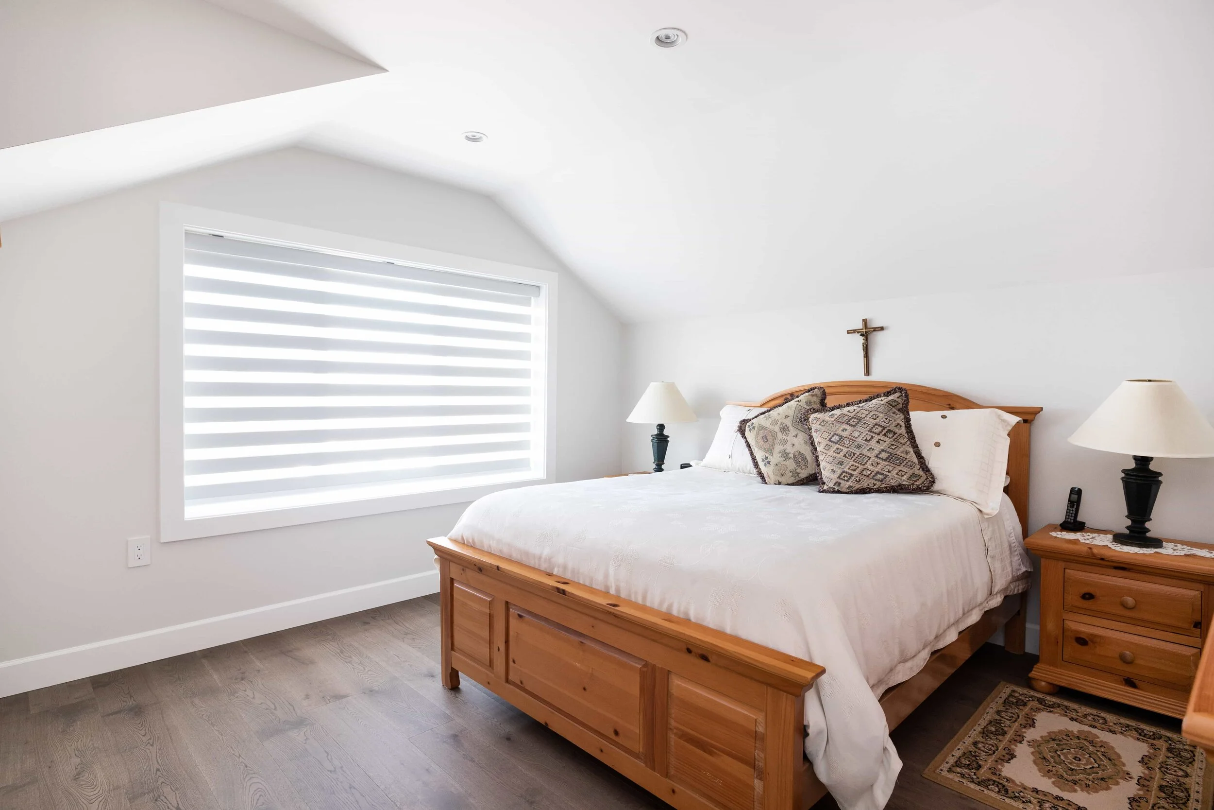 bedroom with light wood furniture and zebra shades