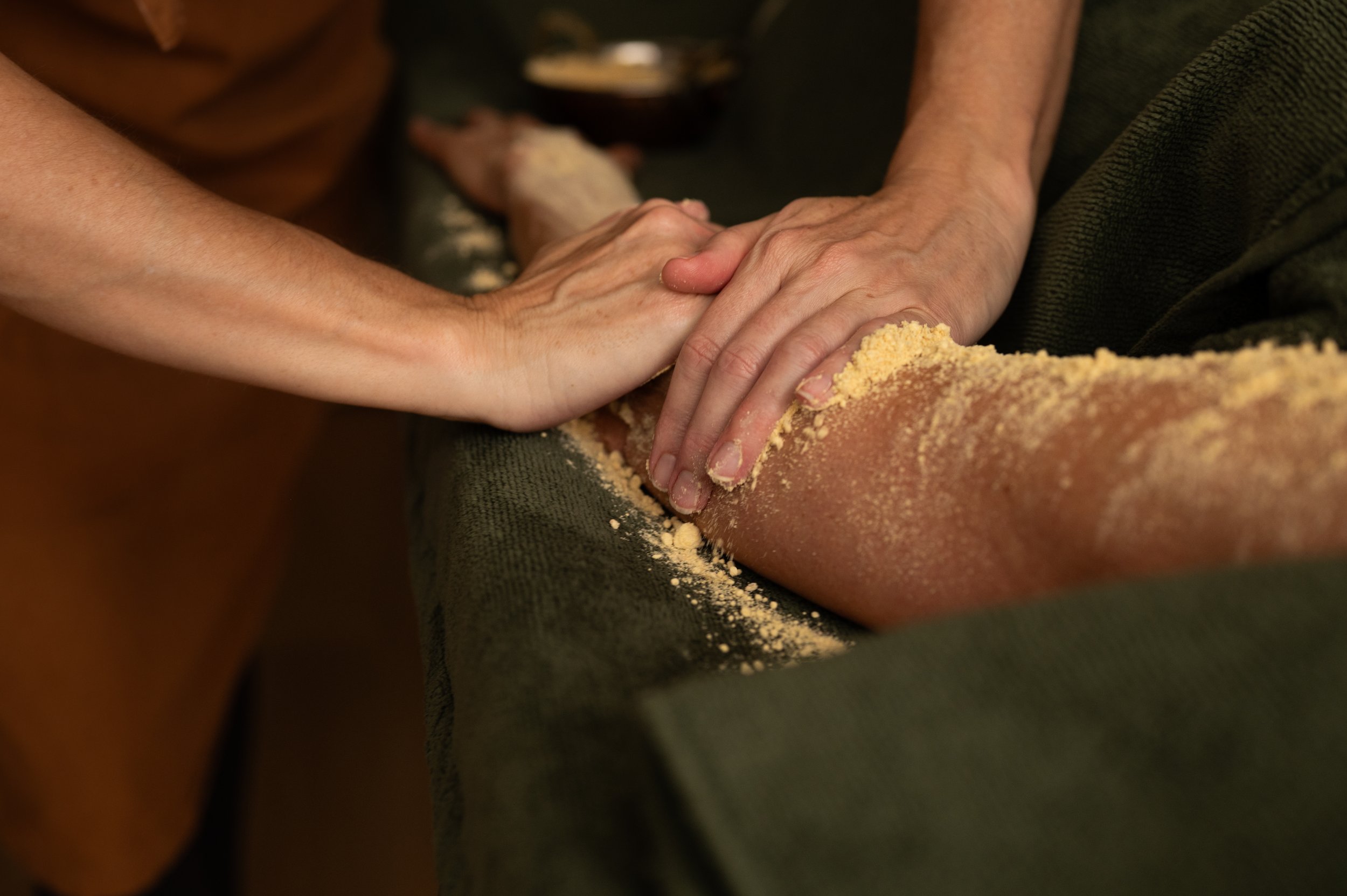 Herbal powder worked into the leg during an Udvartana Ayurvedic massage