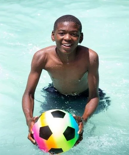 Elias playing with a ball in the pool