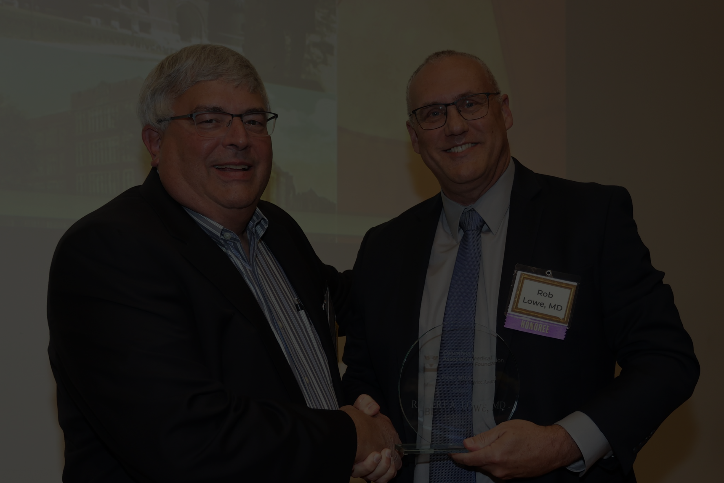 Two men holding award