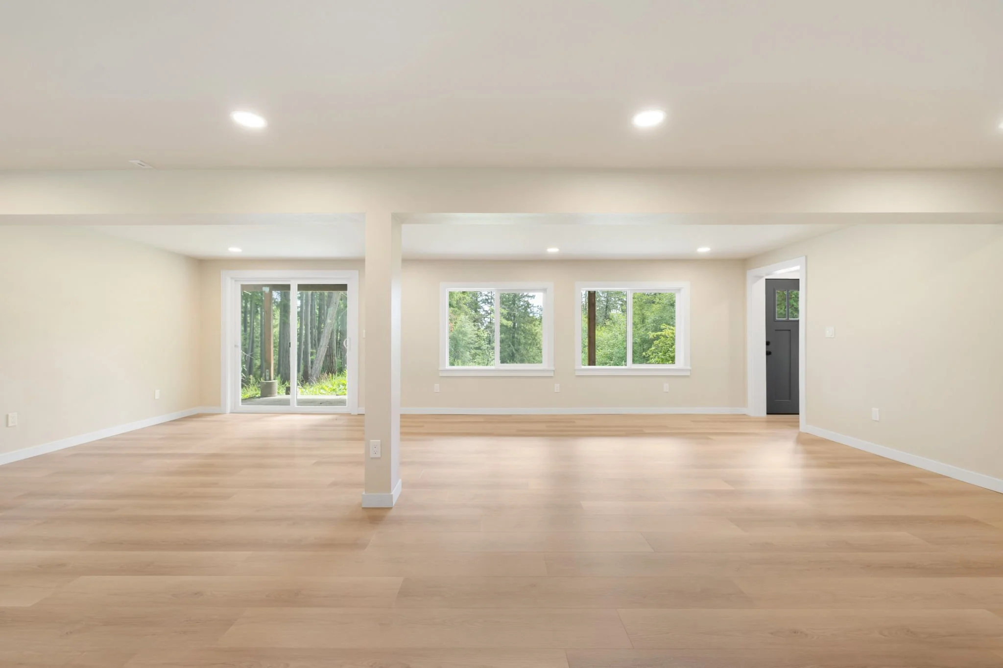 Daylight basement remodel on Fox Island, WA with vinyl flooring, recessed lighting, and windows.