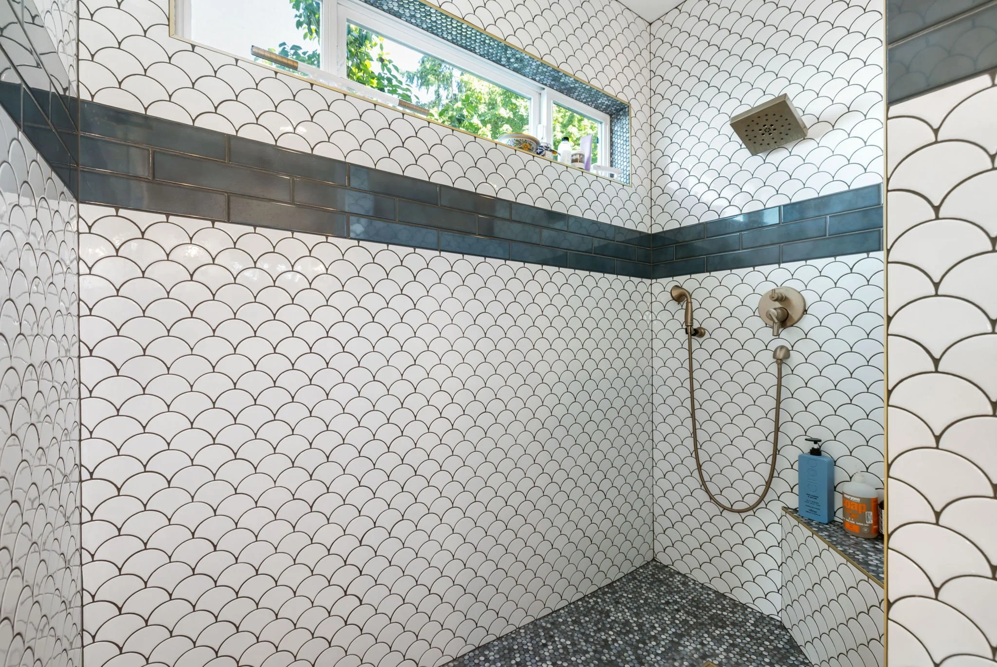 High-end shower remodel in Lakebay, WA with fish-scale tiles and pebbled floor.