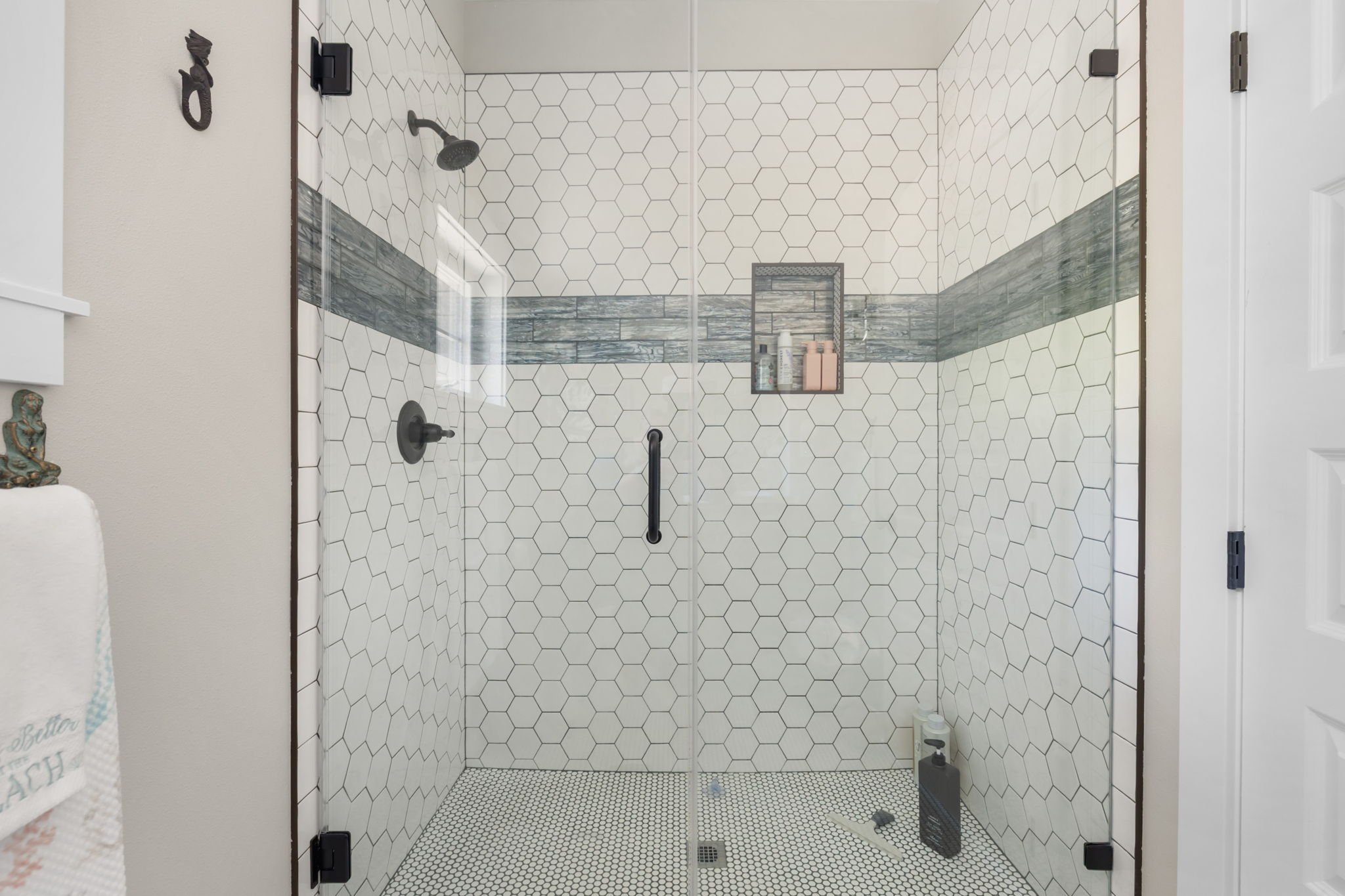 Lakebay, WA shower remodel with hexagonal tile and glass doors.