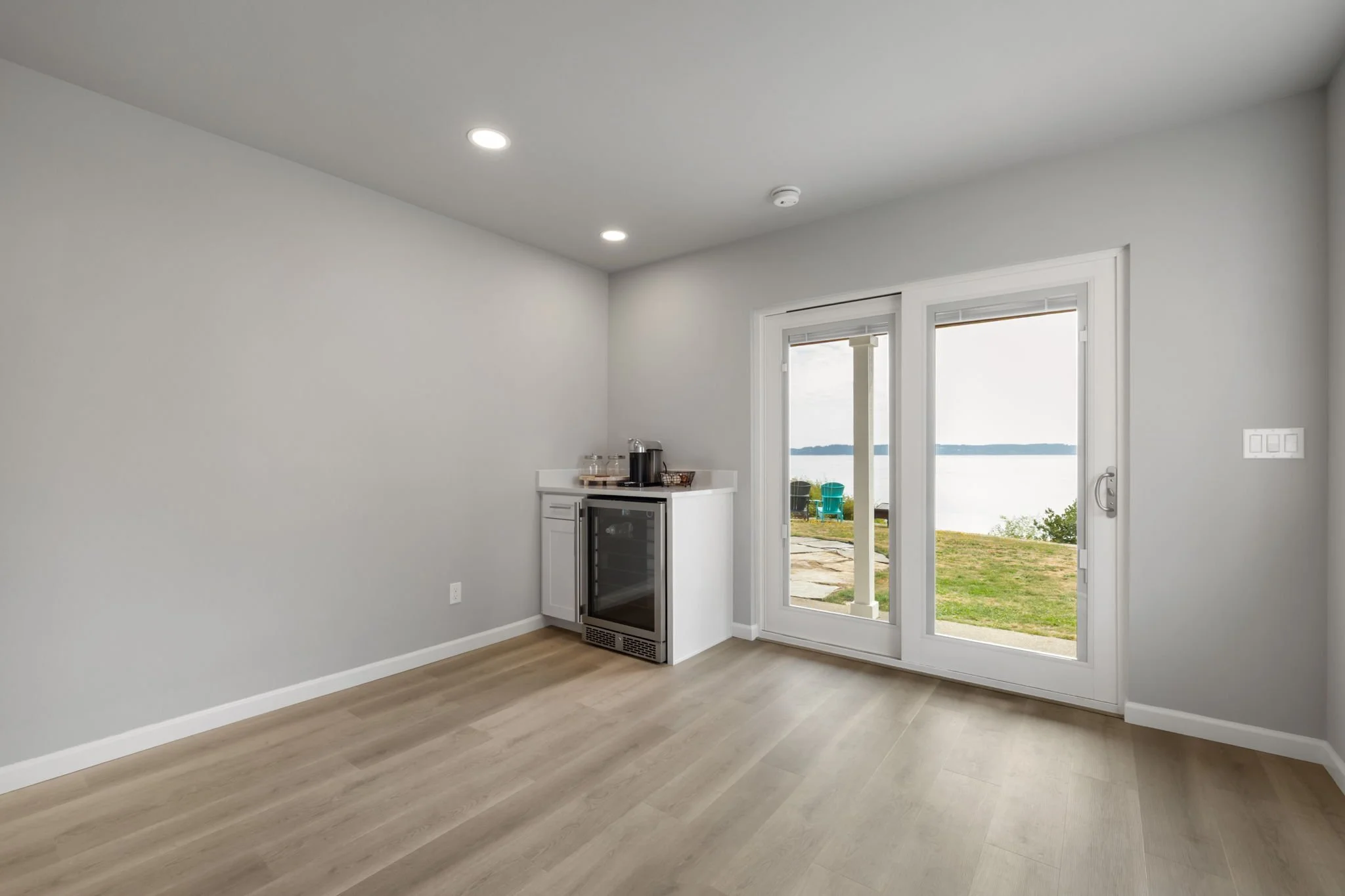 Living area with drink refrigerator and sliding doors with water view in Lakebay.