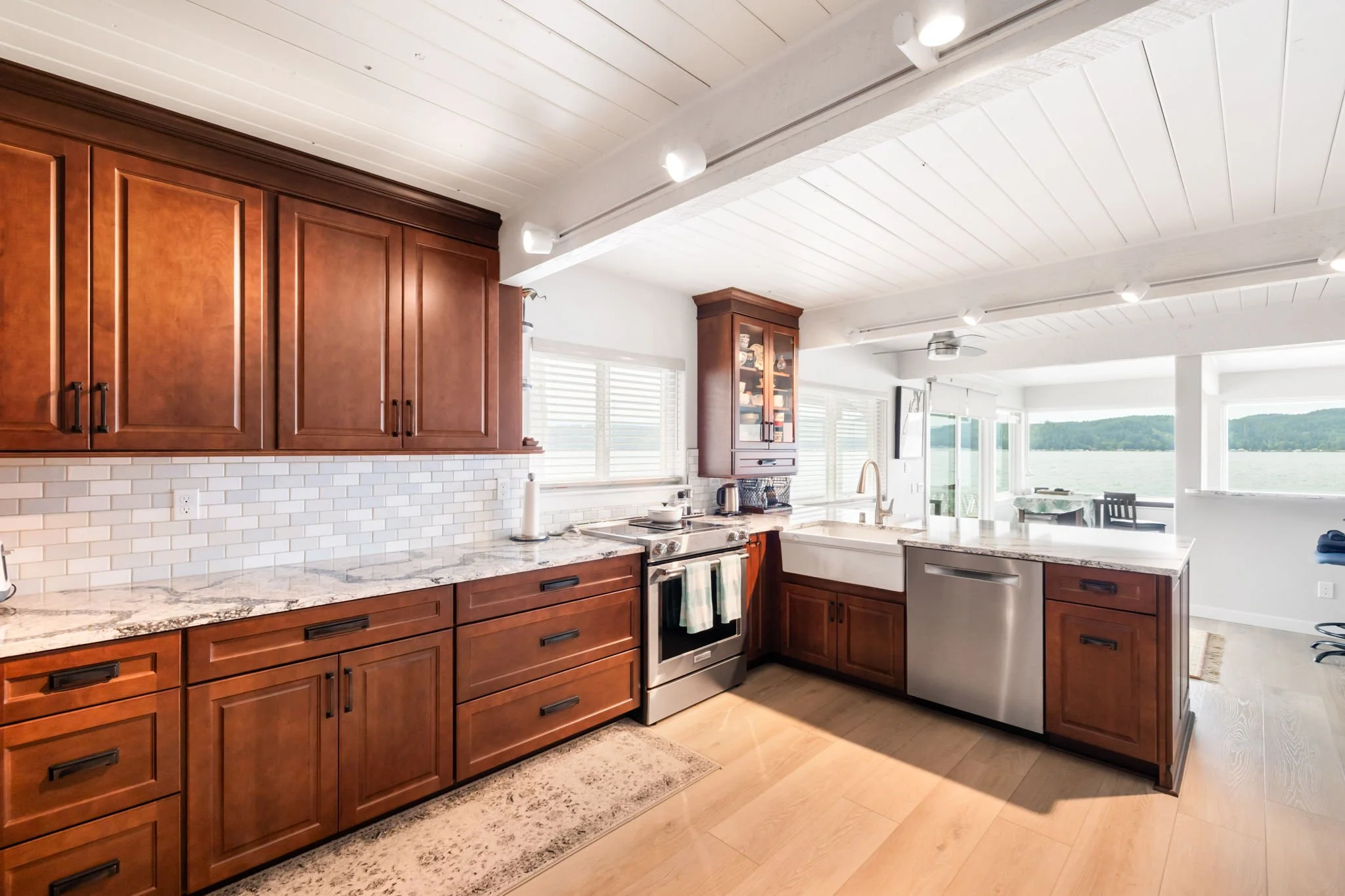 Kitchen remodel in Belfair, WA with dark wood cabinets, quartz counter, and farmhouse sink.