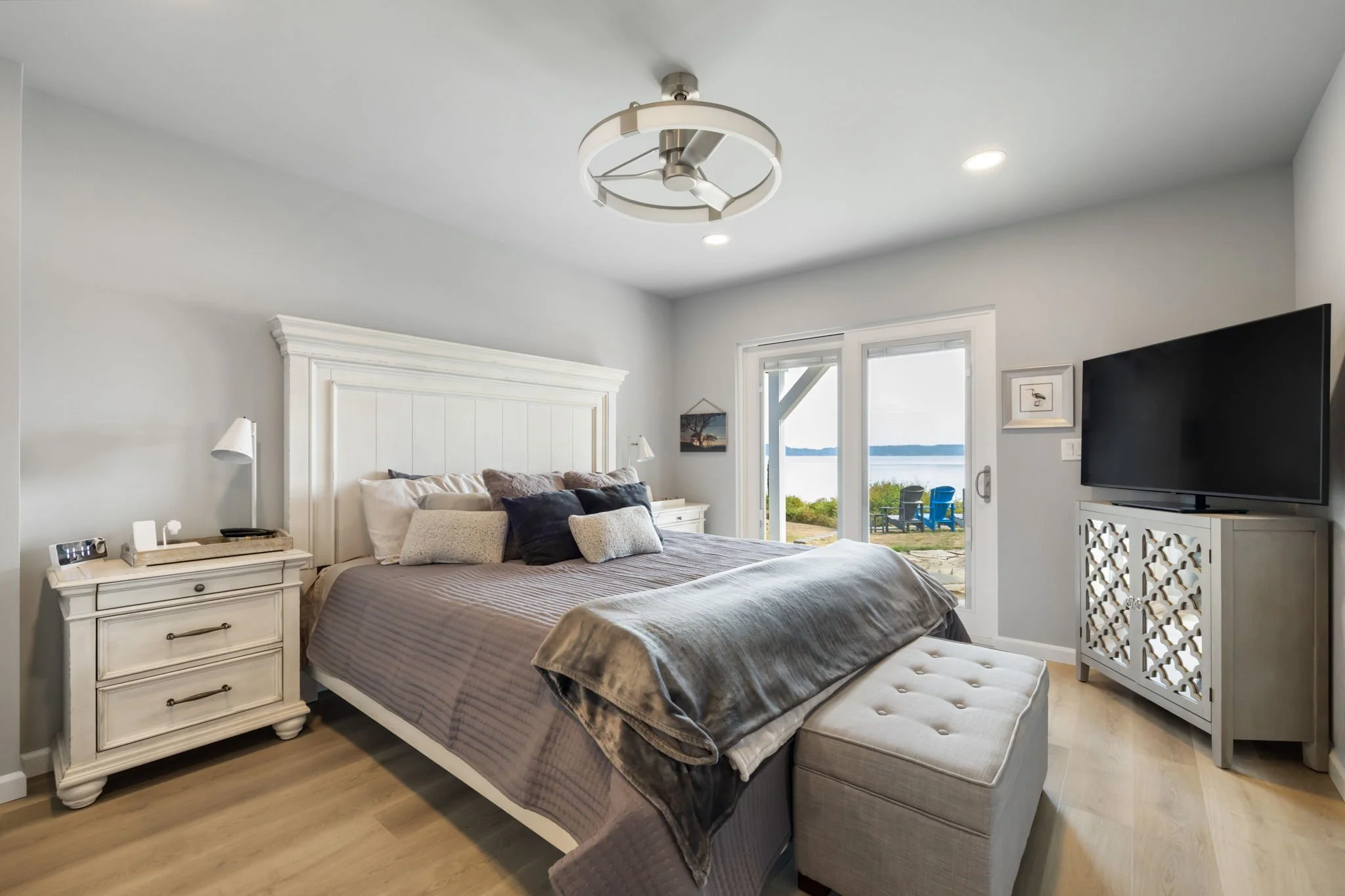 Lakebay bedroom with vinyl flooring, recessed lighting, and sliding doors with water view.