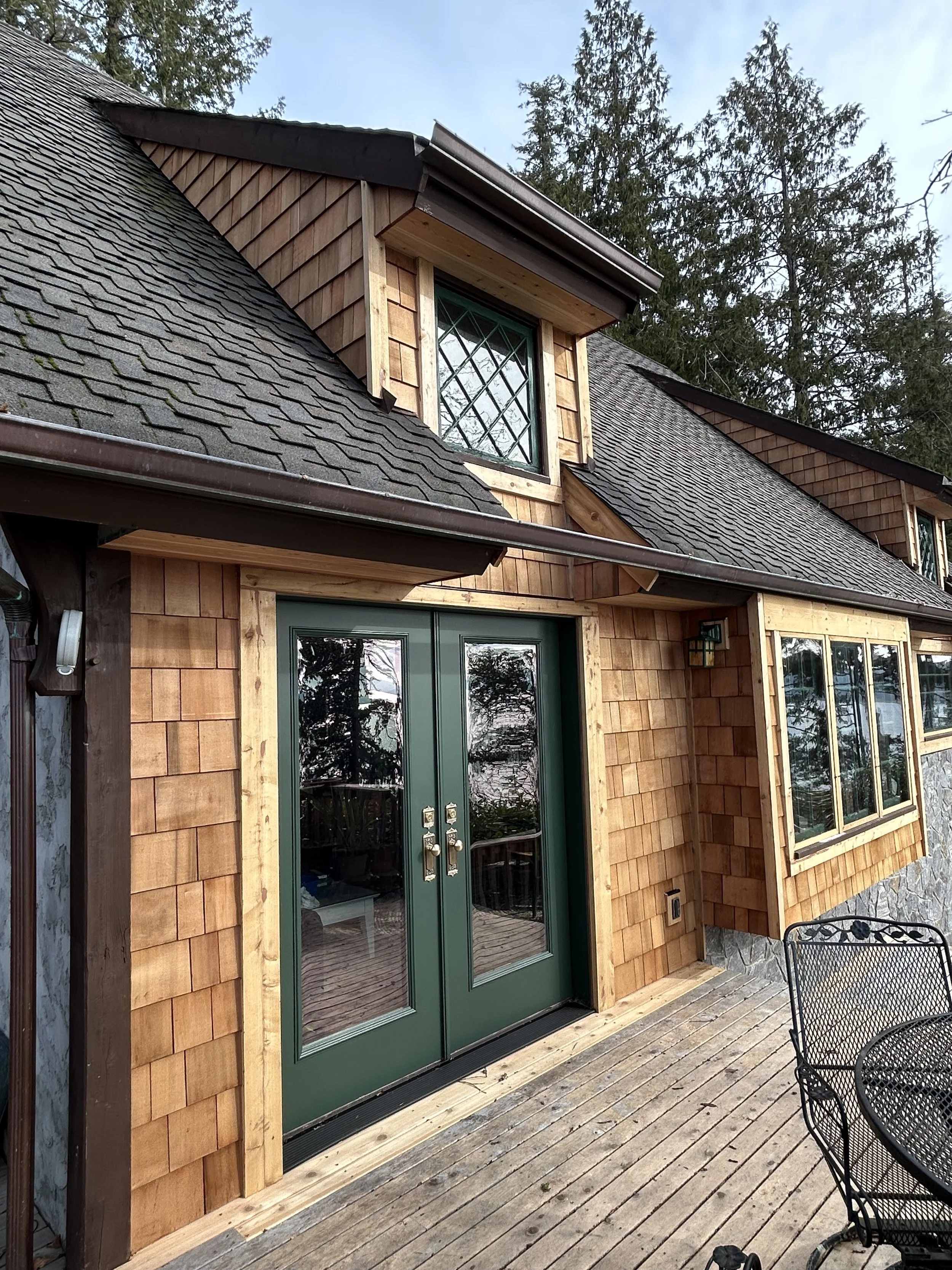 Home repair in Longbranch, WA with wood shingled siding and new glass doors.
