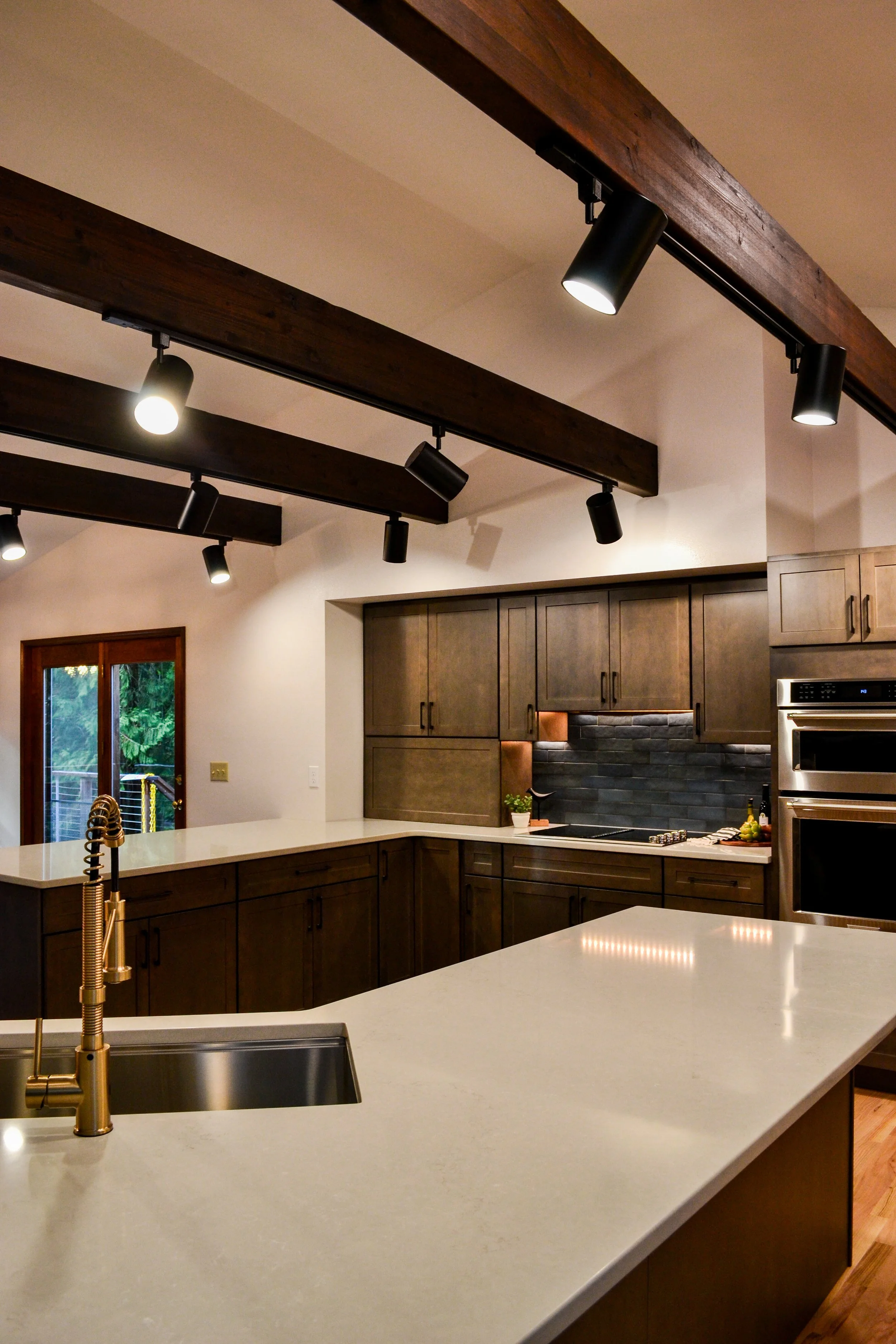 Kitchen remodel in Bremerton, WA with beam ceiling, dark wood cabinets, and stainless appliances..