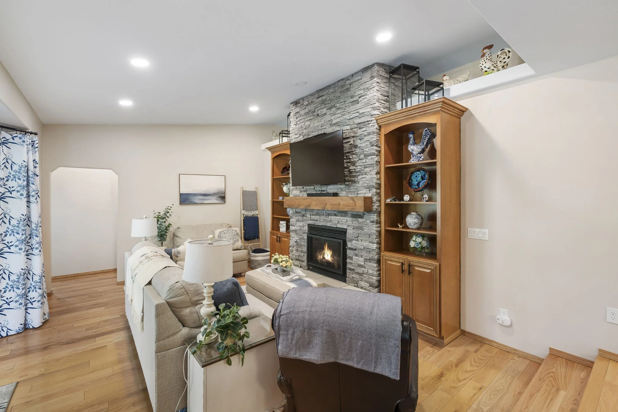 Port Orchard, WA den remodel with stone fireplace and built-in bookshelves.