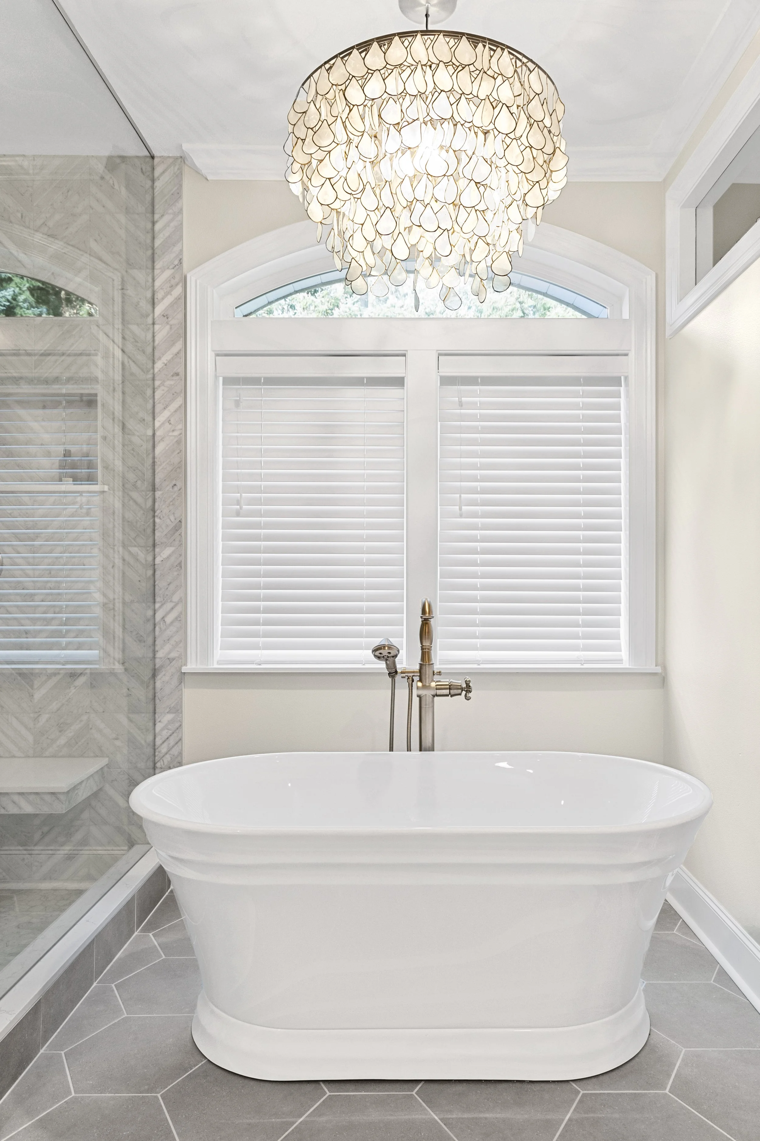 High-end bathroom remodel in Gig Harbor, WA with porcelain stand-alone tub and chandelier.
