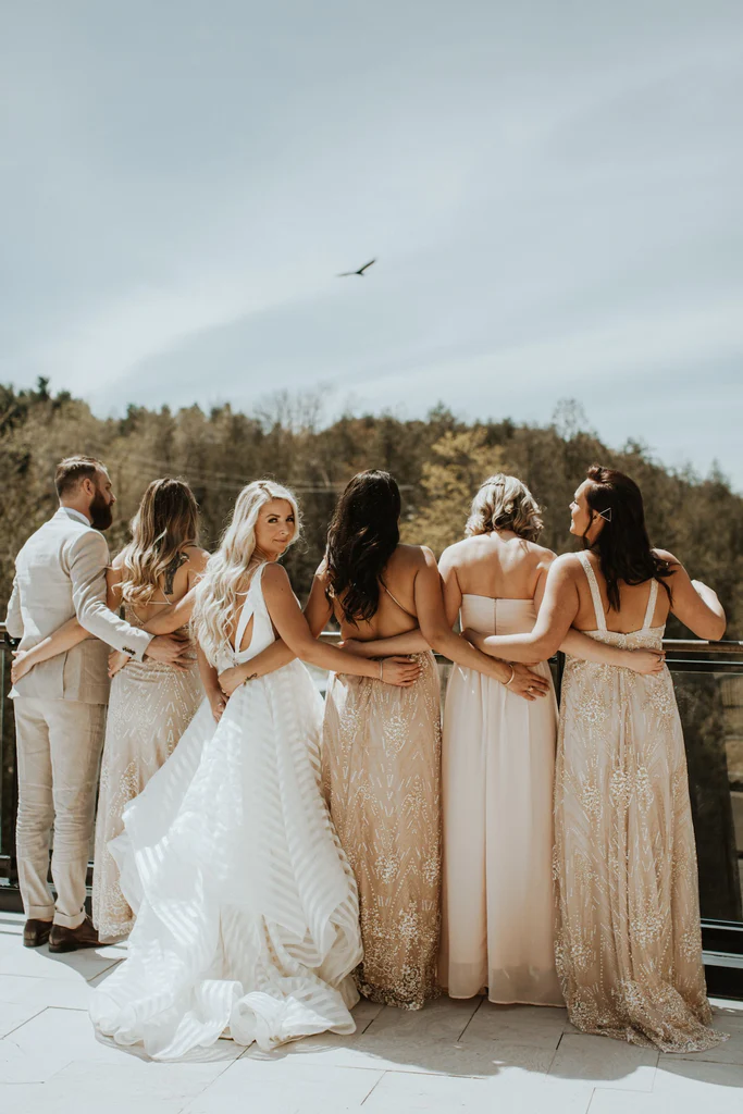  A bride and her bridal party pose for a picture inside Elora Mill. 