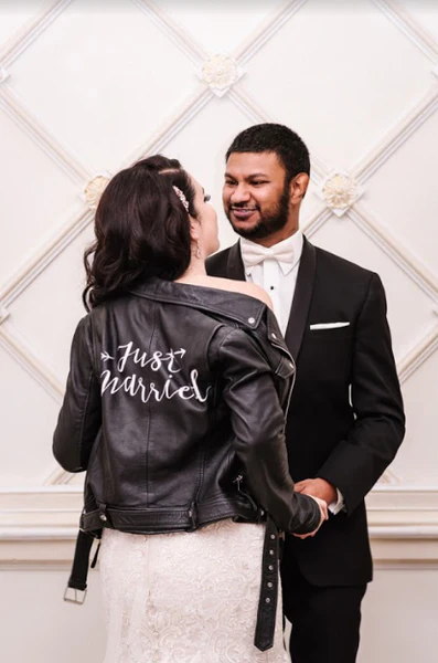 The bride shows off her Just Married Jacket with her new husband.