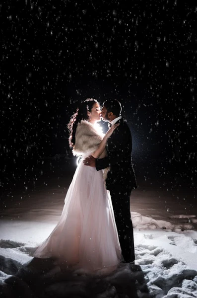The bride and groom share a kiss at night at a glamorous Toronto winter wedding.