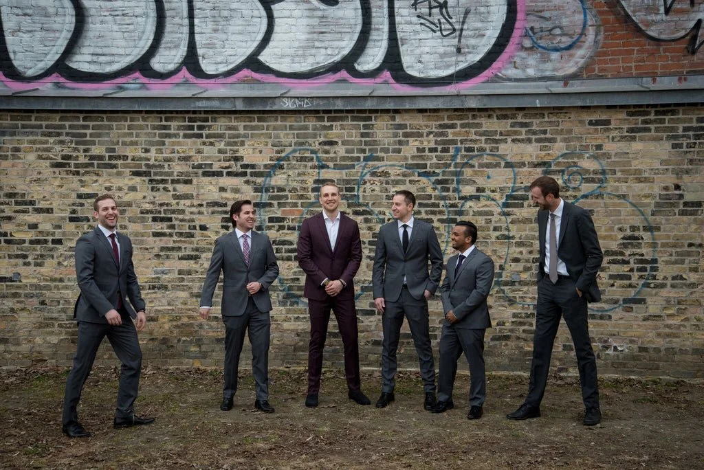 The groomsmen and the groom pose for a photo.