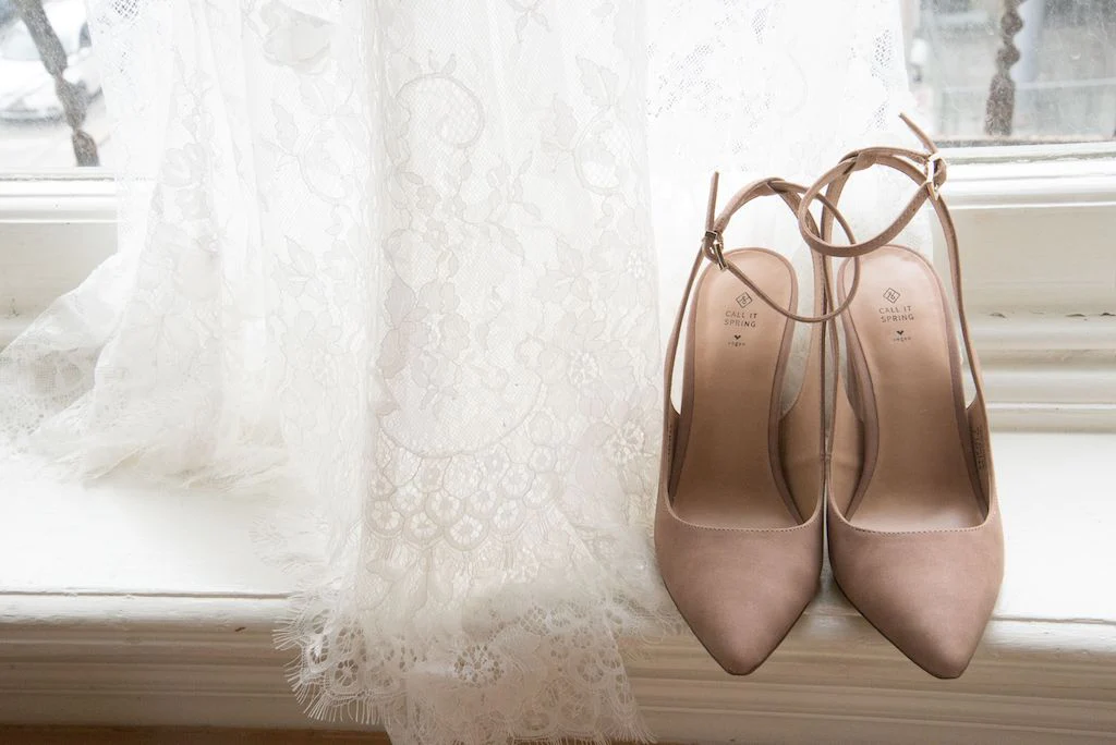A bride's beige wedding shoes and wedding dress.