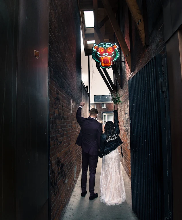 A newlywed couple walk to a restaurant for their reception.