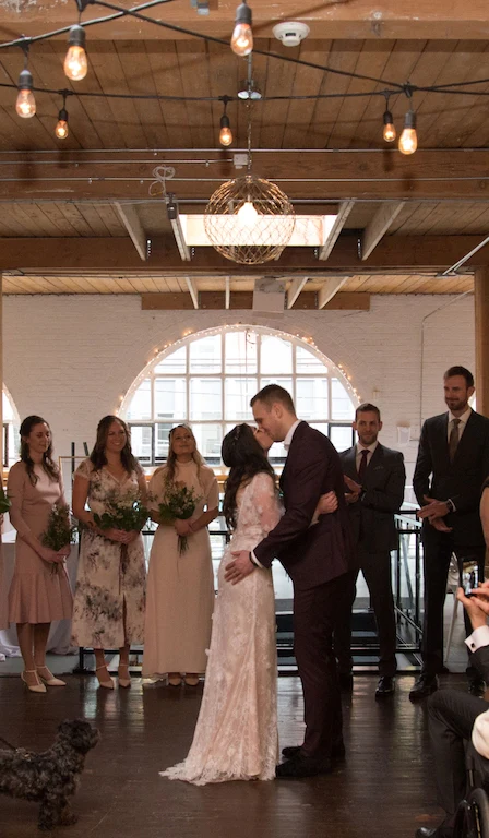 A bride and groom kiss at their wedding inside Twisted Gallery in Toronto.