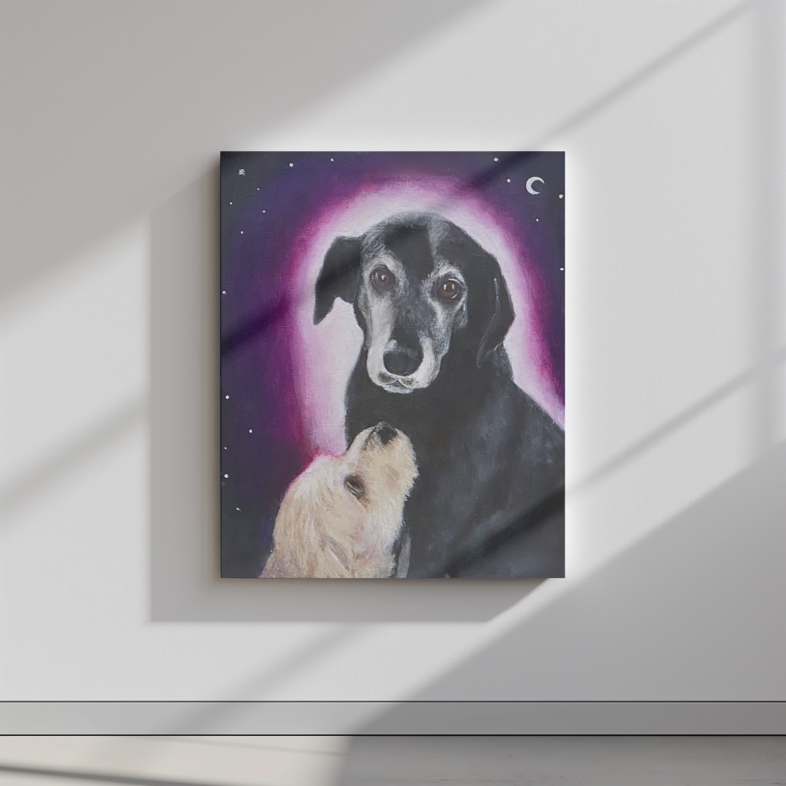 Fine art print of a dog portrait featuring an older black dog with a pink halo and a white dog looking up at them under a crescent moon by Diantha Boardman.