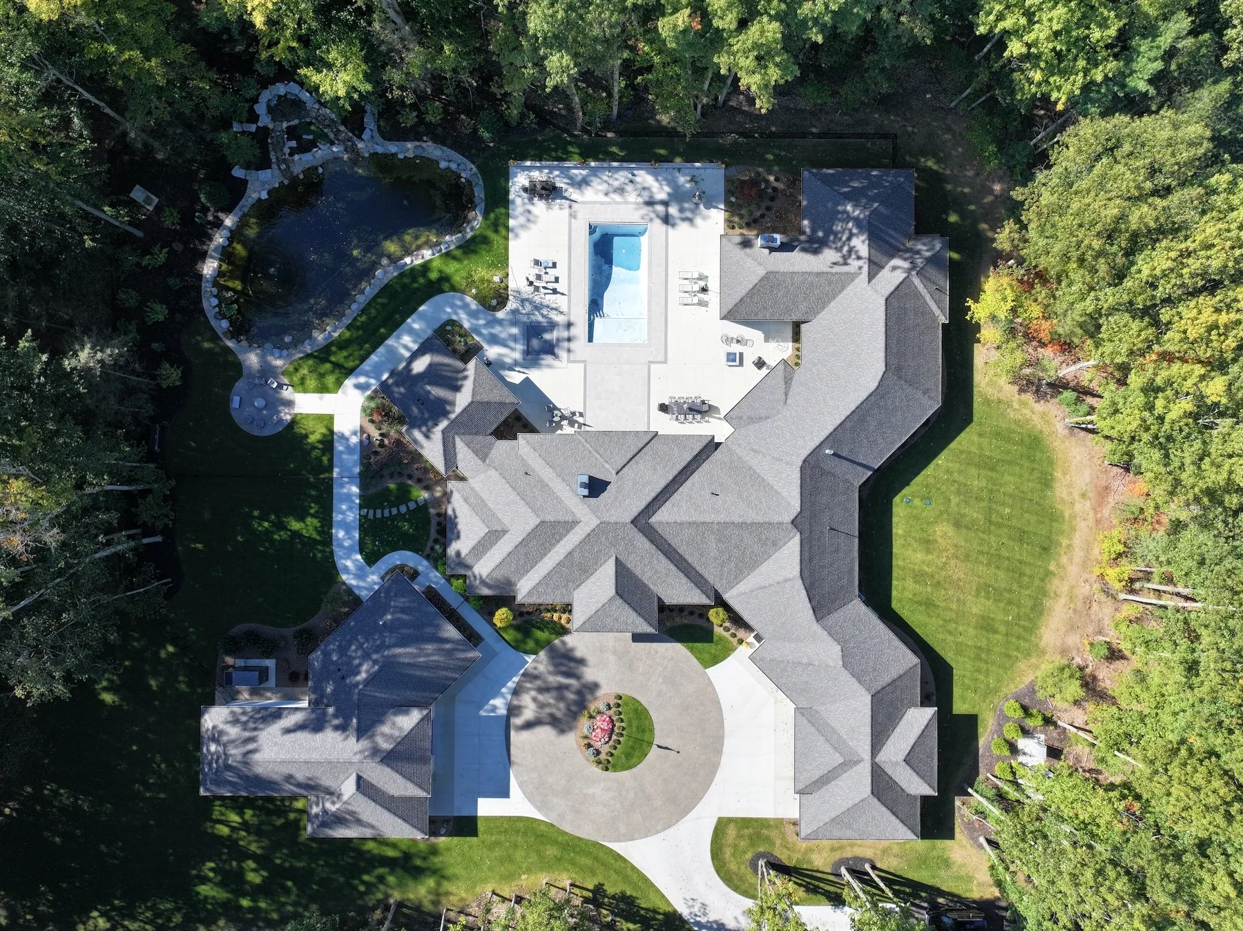 Patio featuring a pool, hot tub, fire pit, and outdoor kitchen in Holland, MI